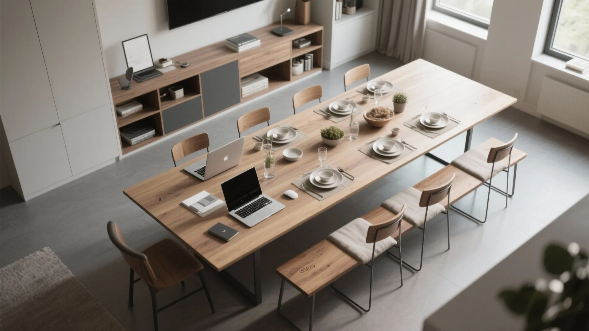 Large wooden table used as a workstation with laptops and dining sets in modern office
