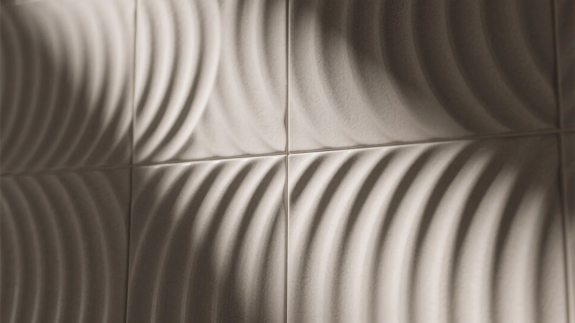 Close up view of white 3D wall tiles with wavy texture and soft grey shadows