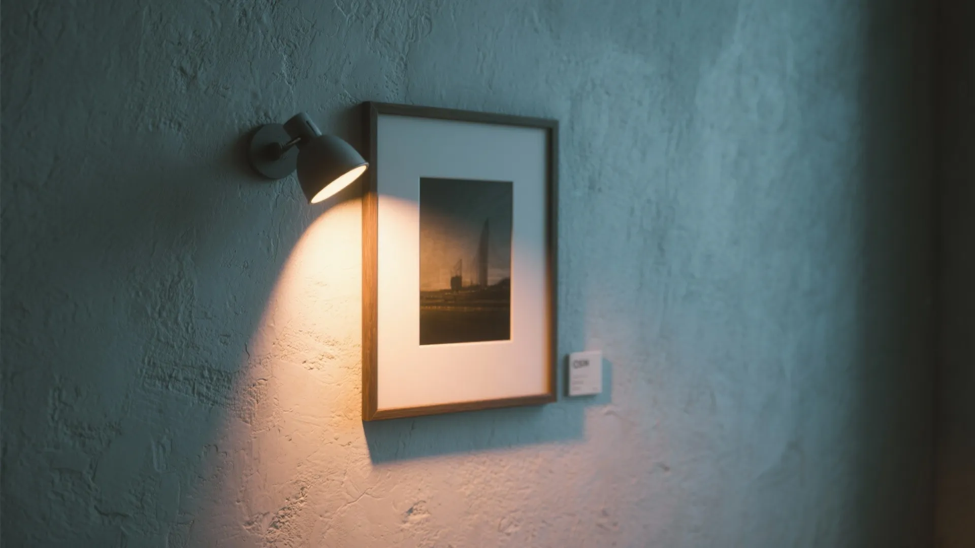 Accent spotlight highlighting framed art on a textured wall in a small room
