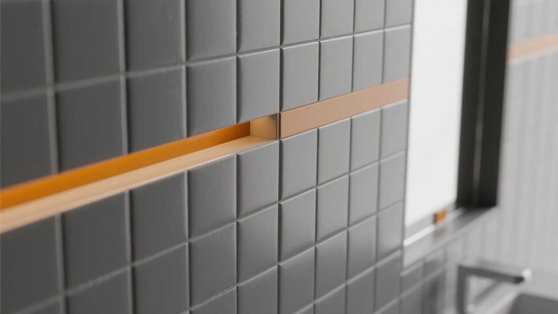 Close up of grey square wall tiles with a horizontal orange light strip for bathroom