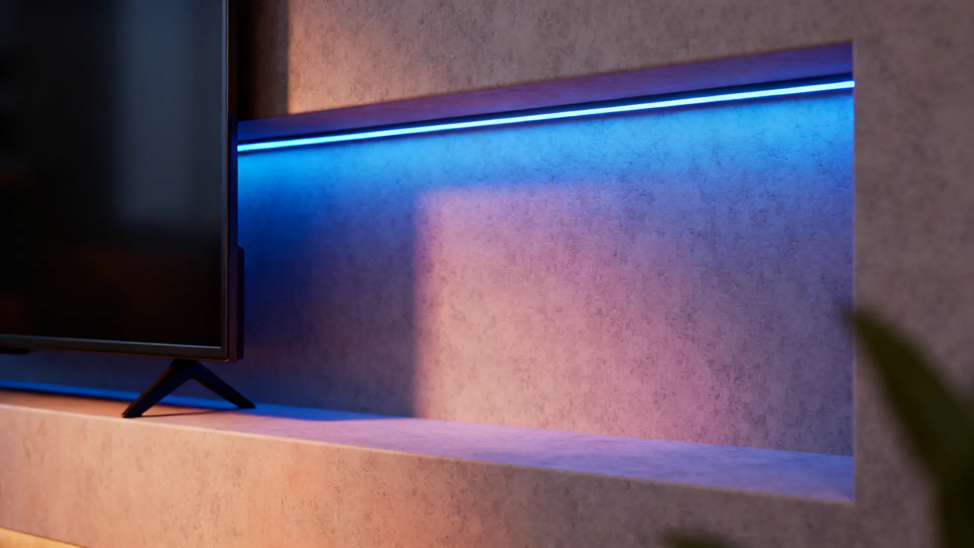 Close-up of a TV alcove with subtle blue RGB LED accent lighting creating a cinematic mood.