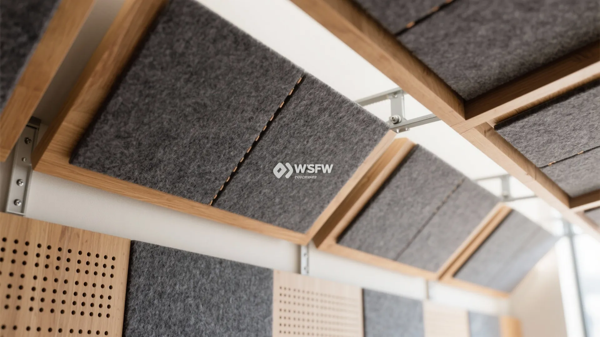 Macro detail of acoustic felt baffles and fabric wall panels with perforated wood trim for better speech clarity.