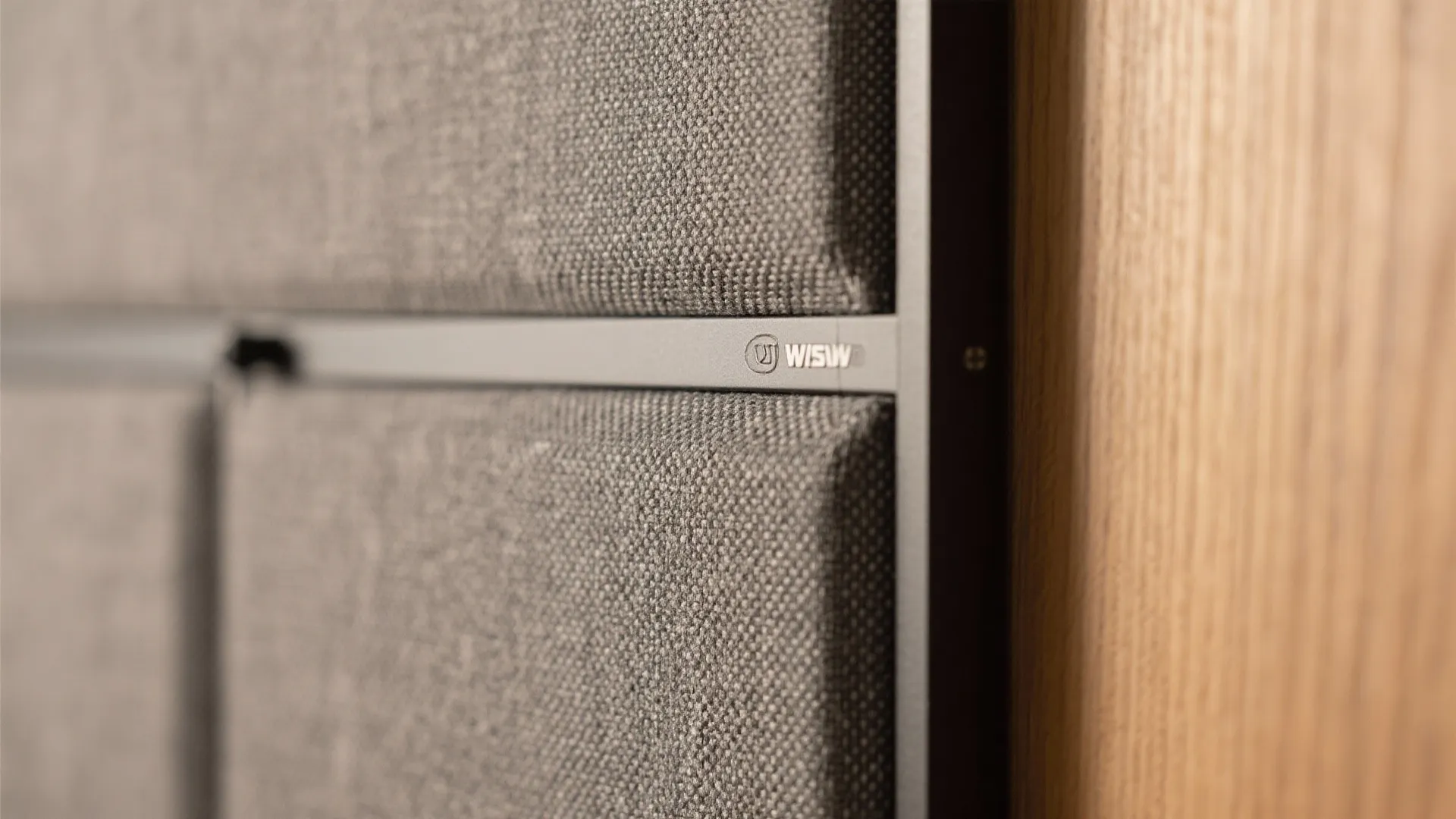 Macro of acoustic fabric panel on a magnetic frame beside oak veneer