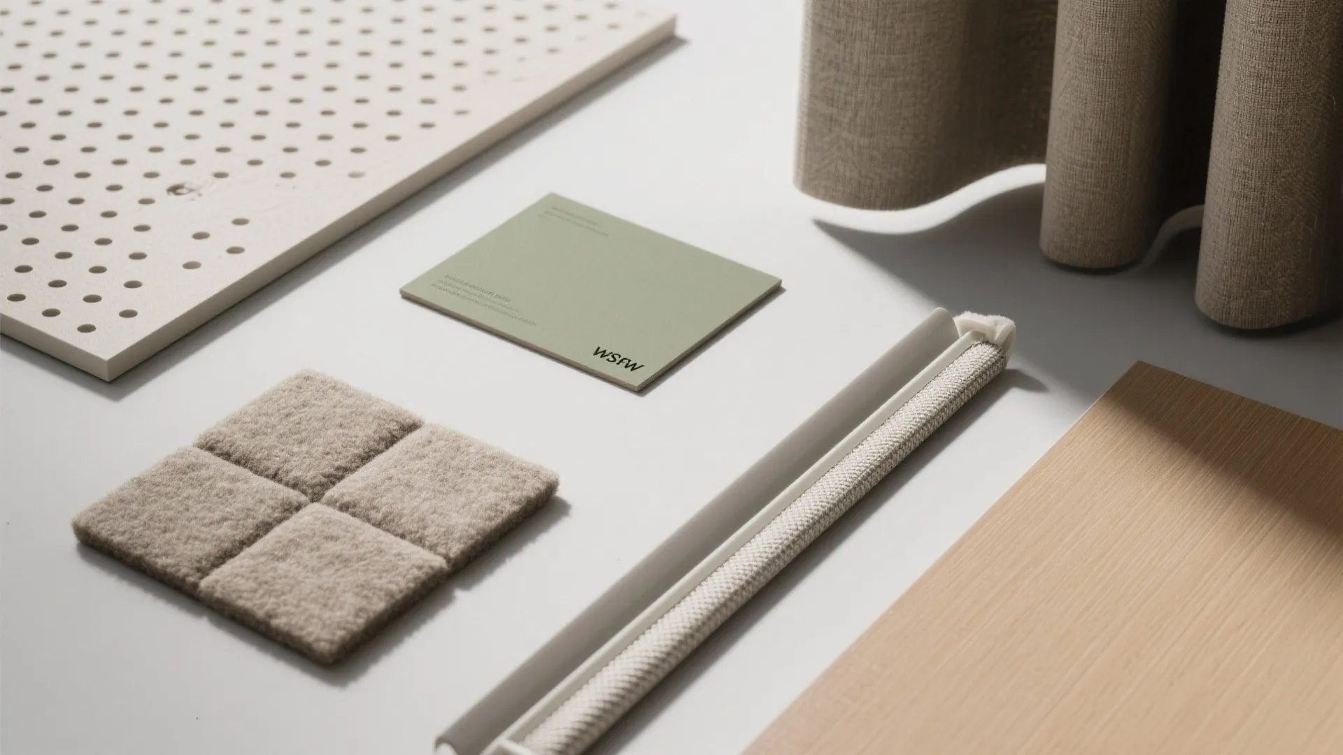 Interior design materials including fabric samples and wood panels organized on a clean white surface