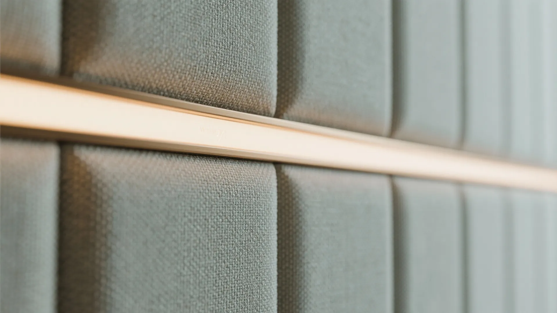 Close up of grey fabric wall panel with a warm light strip built into middle
