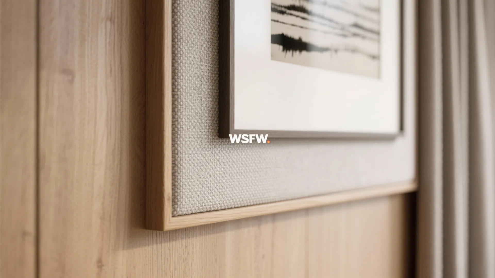 Wooden picture frame on fabric wall panel with light wood wall texture in modern home design