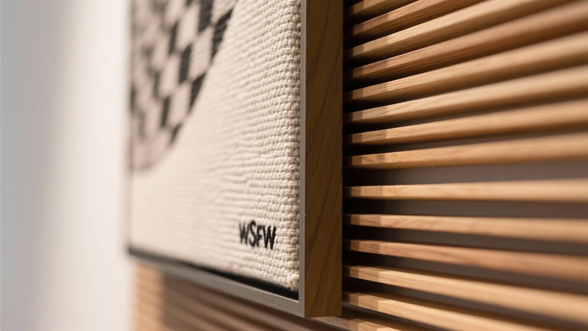 Close up view of a textured wall panel next to horizontal wooden slats in sunlight