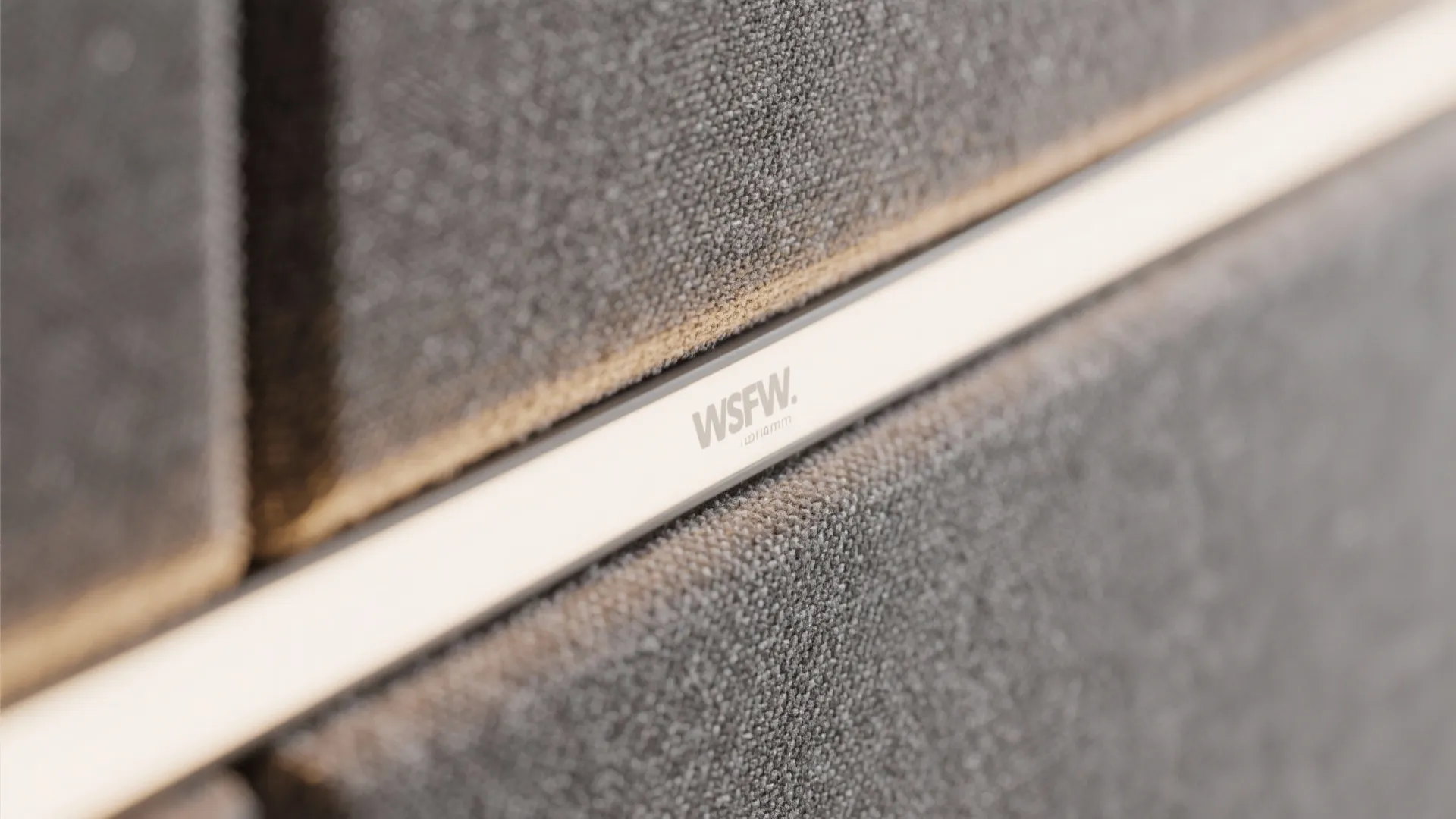 Close-up of an acoustic panel with a precise vertical light slot and warm glow.