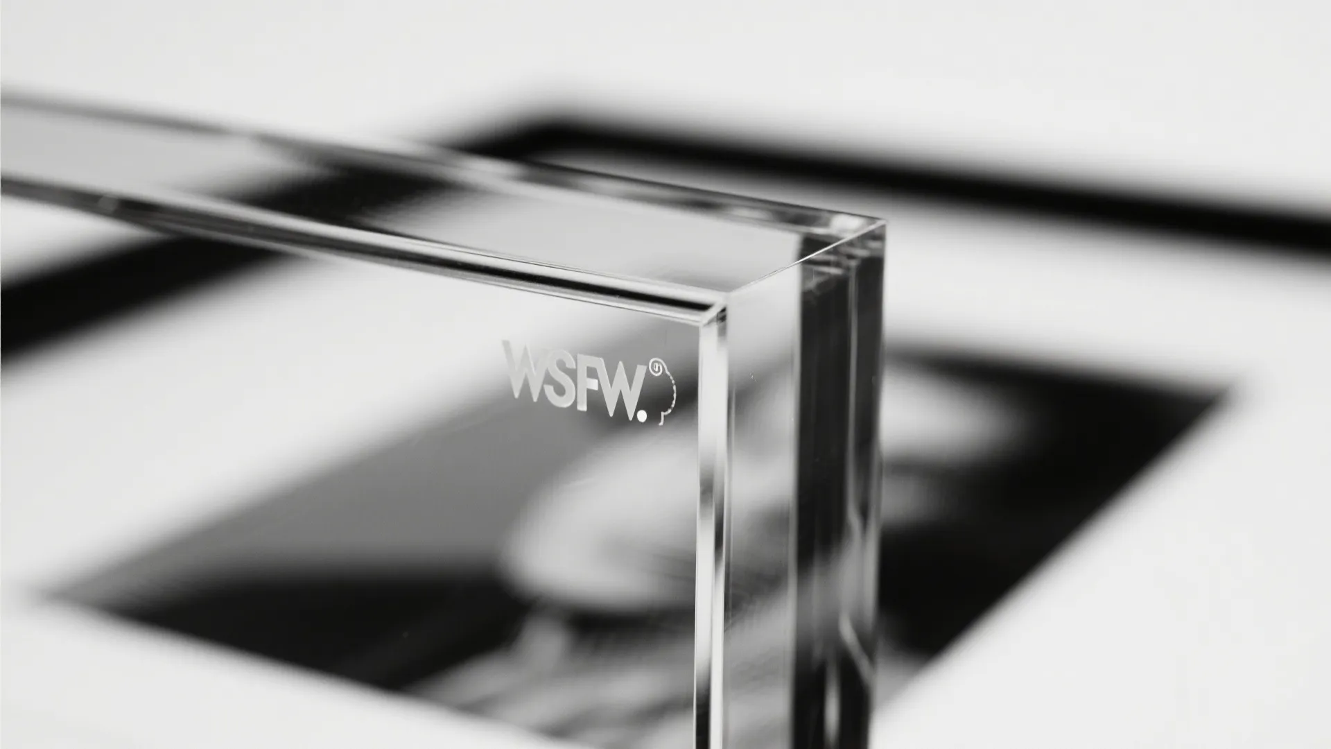 Close up view of a clear plastic block with engraved text showing transparent material details