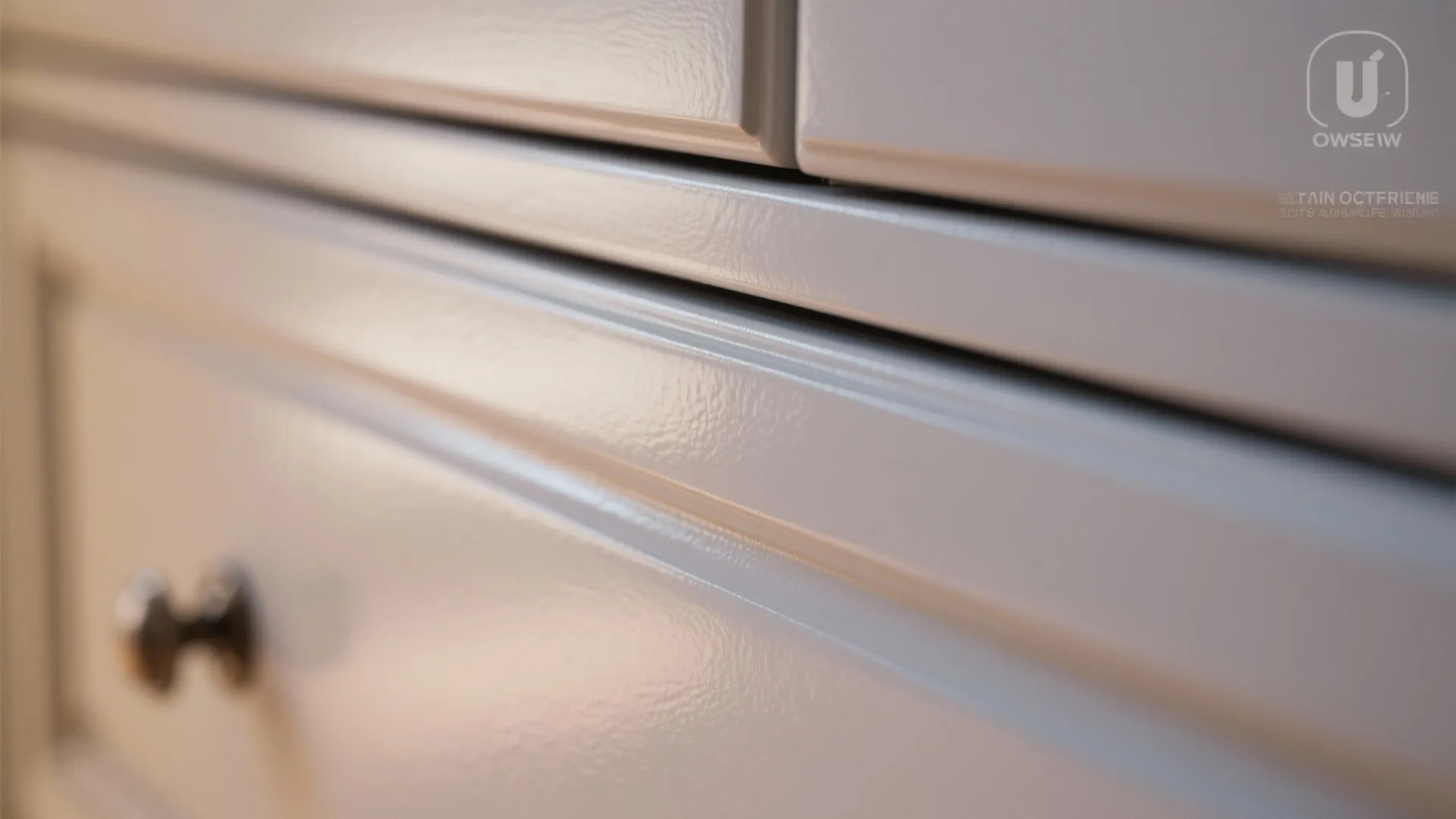 Close up view of glossy light grey painted cabinet drawer with a small metal handle
