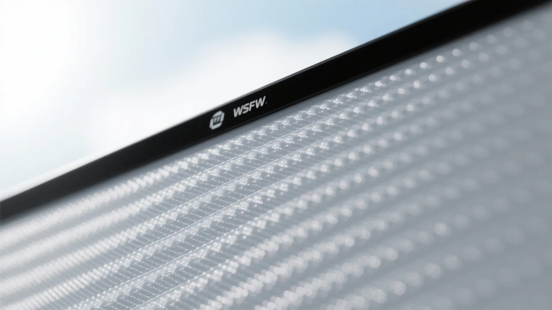Close up of gray textured projector screen showing mesh surface and black frame with logo