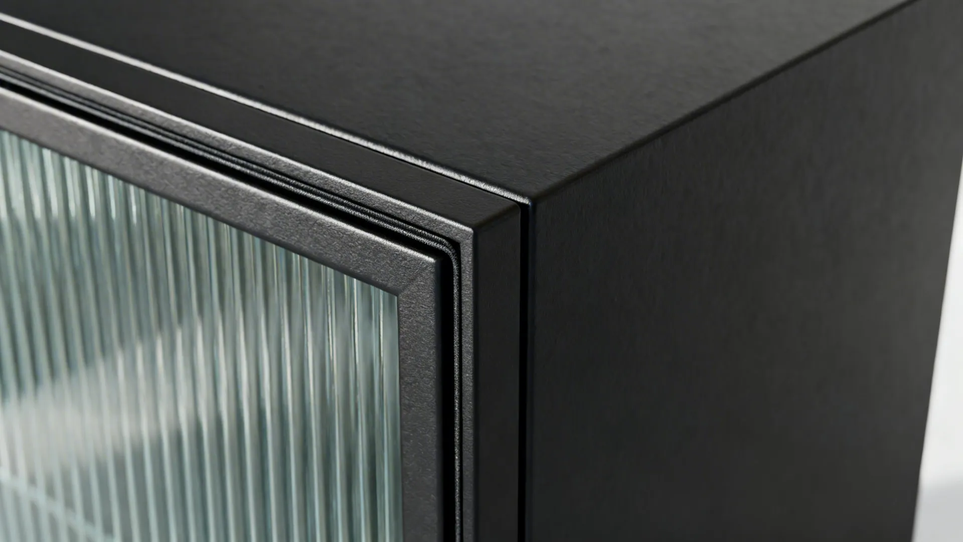 Close-up detail of a black metal cabinet frame featuring a glass door with vertical lines