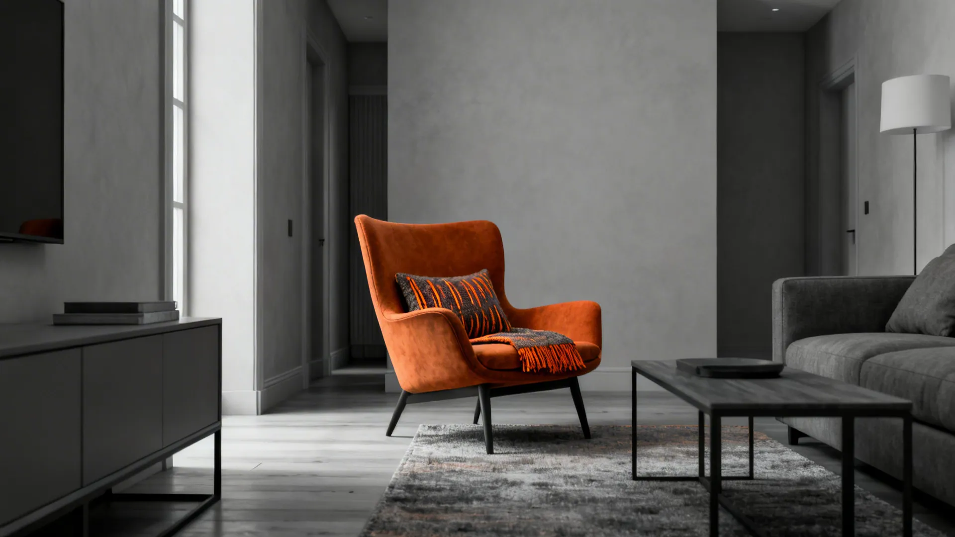 Grey living room anchored by a single burnt orange chair and a matching textile accent.