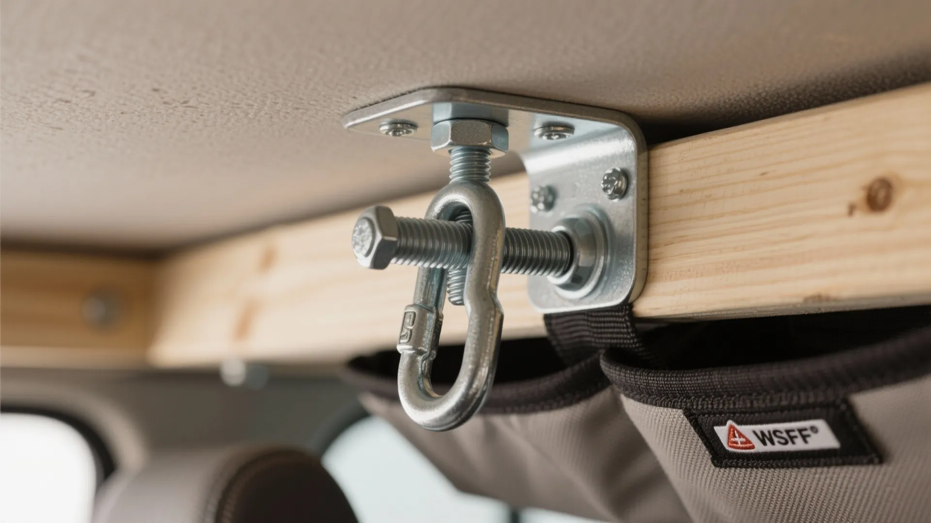 Metal hook and bolt hardware attached to a wooden beam for hanging heavy storage bags