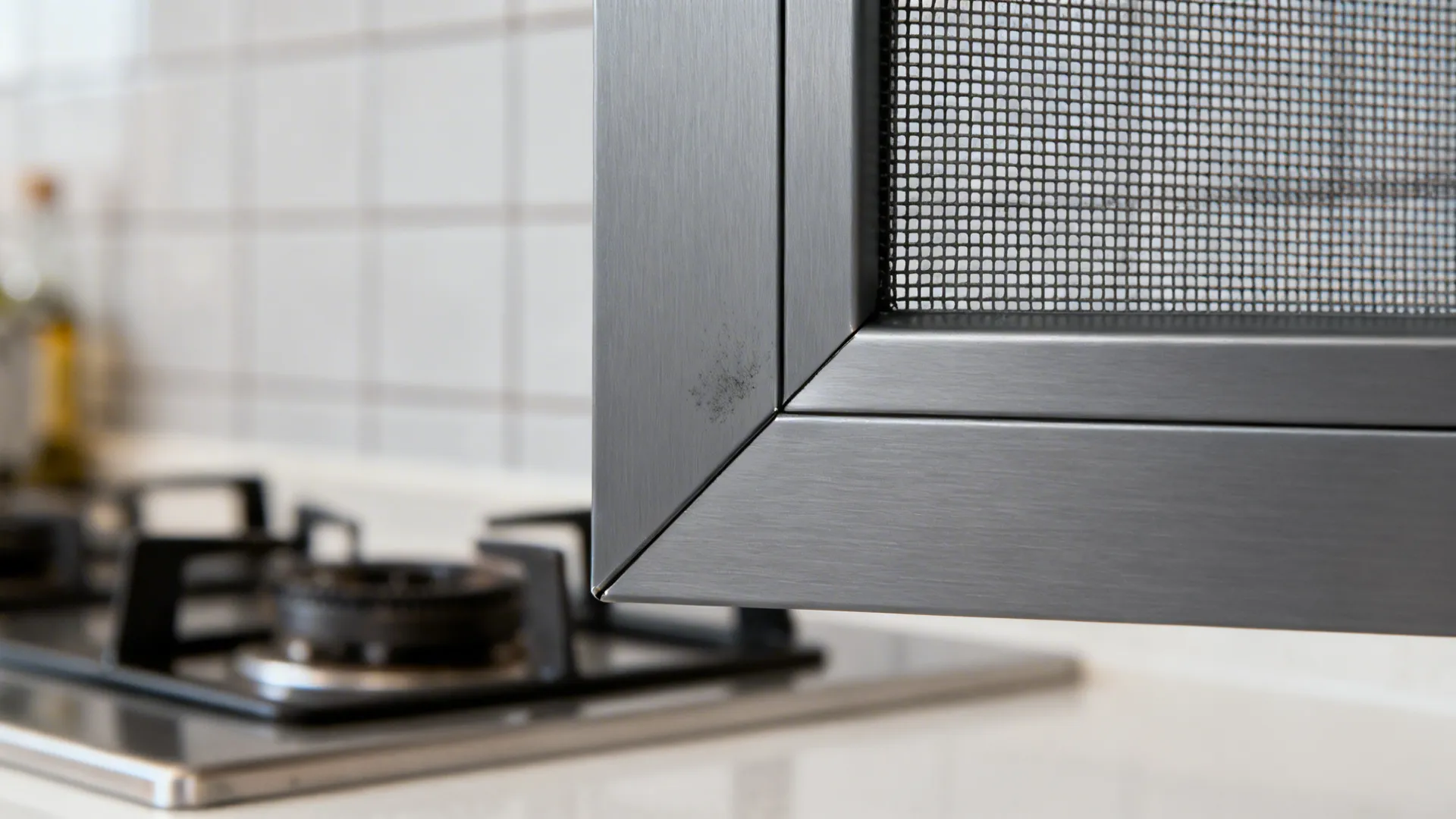 Macro of a matte anodized aluminium grill corner joint with precise mitred finish.