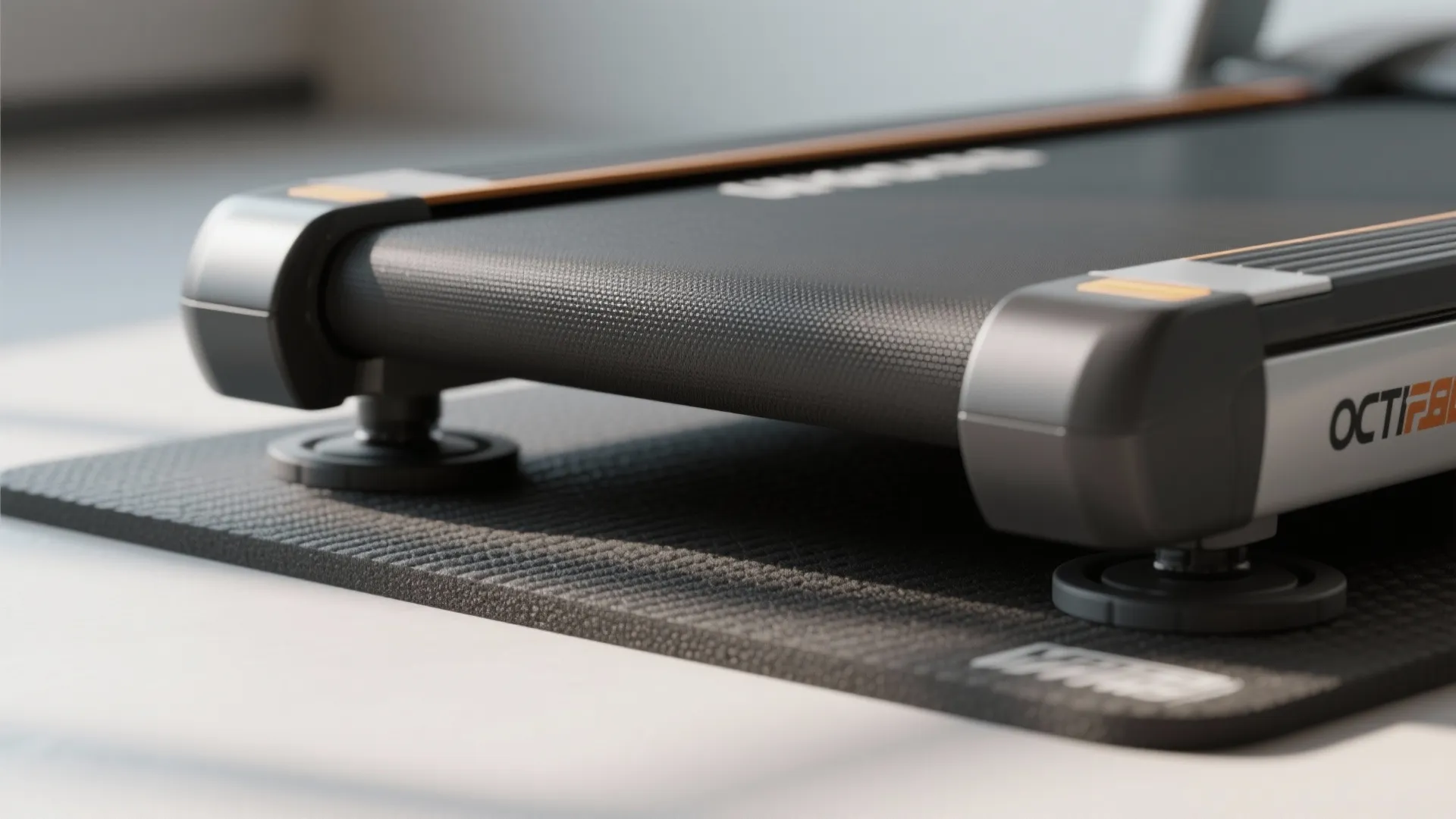 Black treadmill placed on a thick protective rubber mat for floor protection and noise reduction