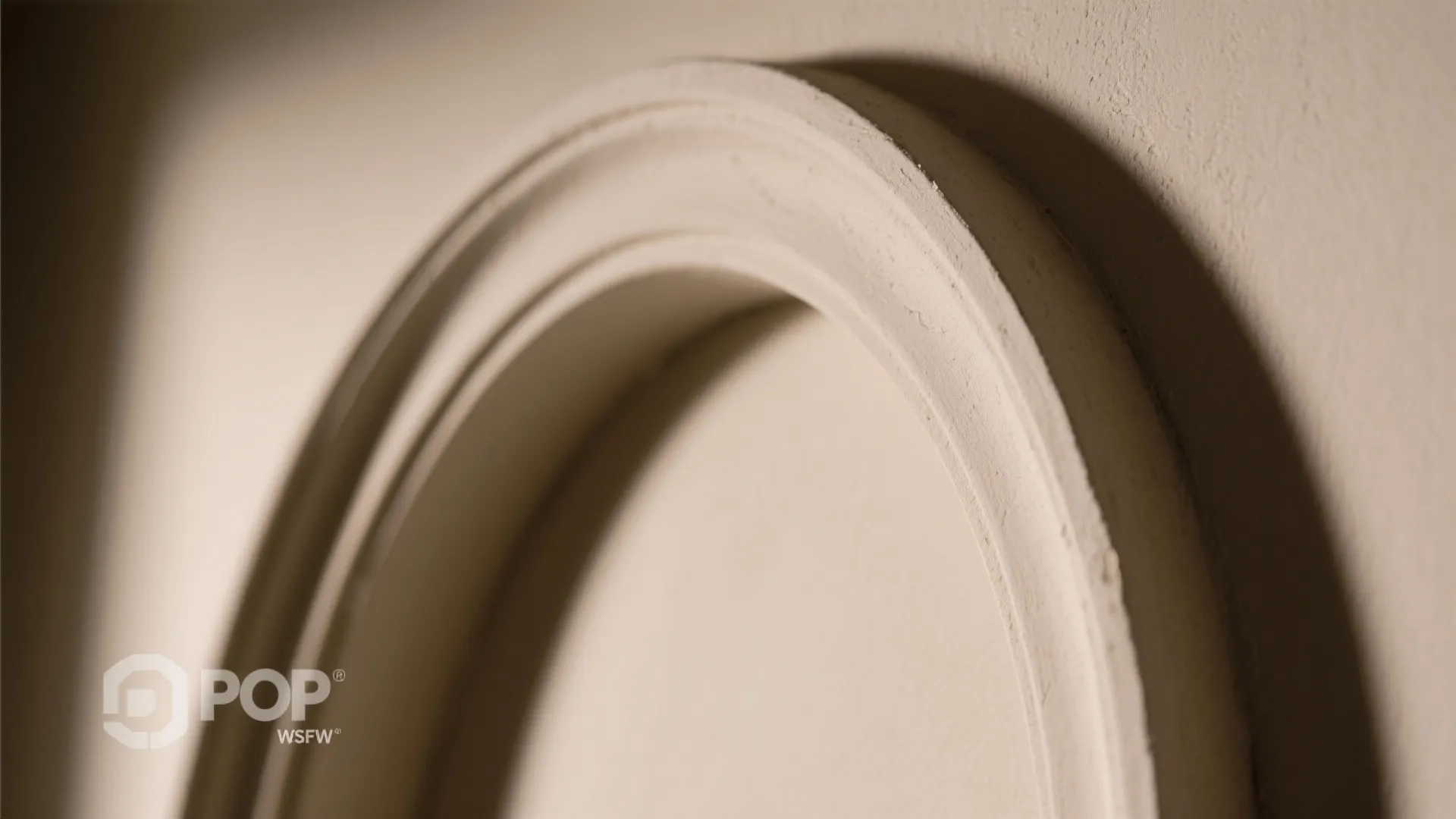 Close up of a curved white wall panel with decorative round edge in neutral interior