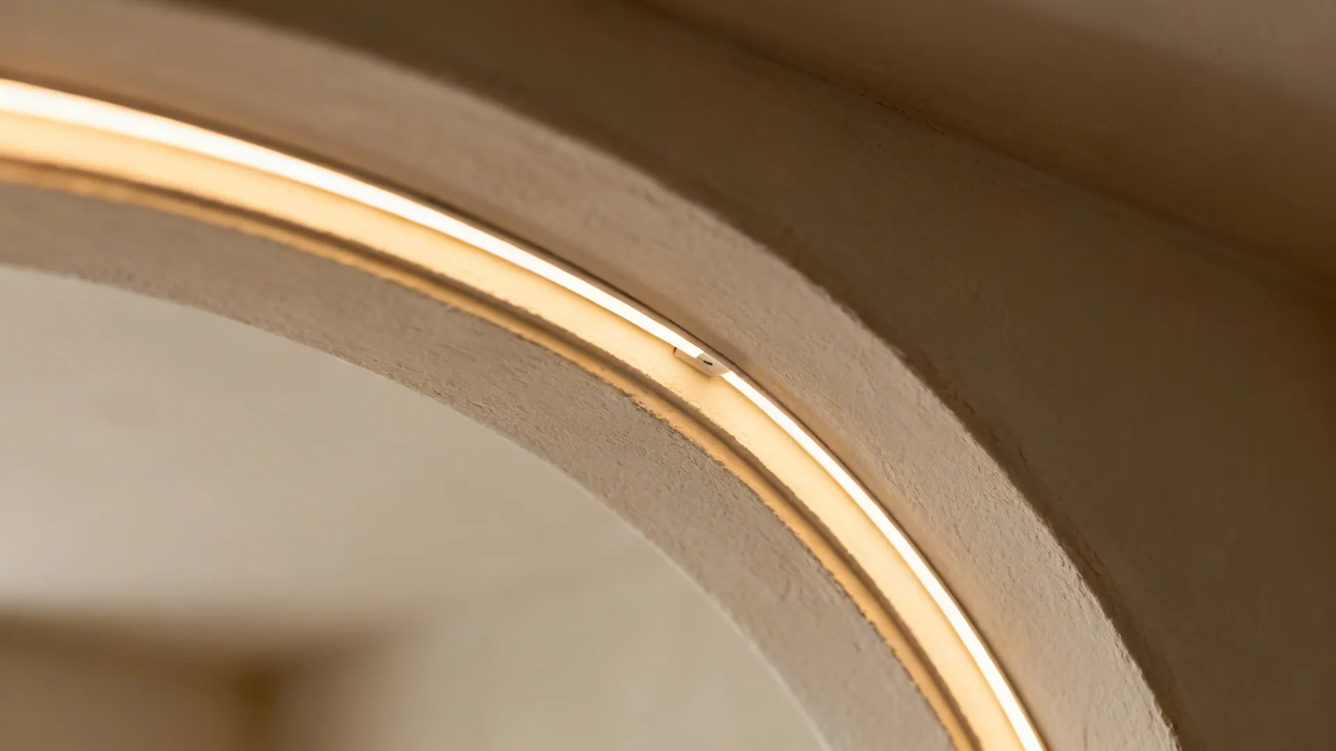 Close-up of a concealed linear LED within a plaster arch soffit at a kitchen entry.