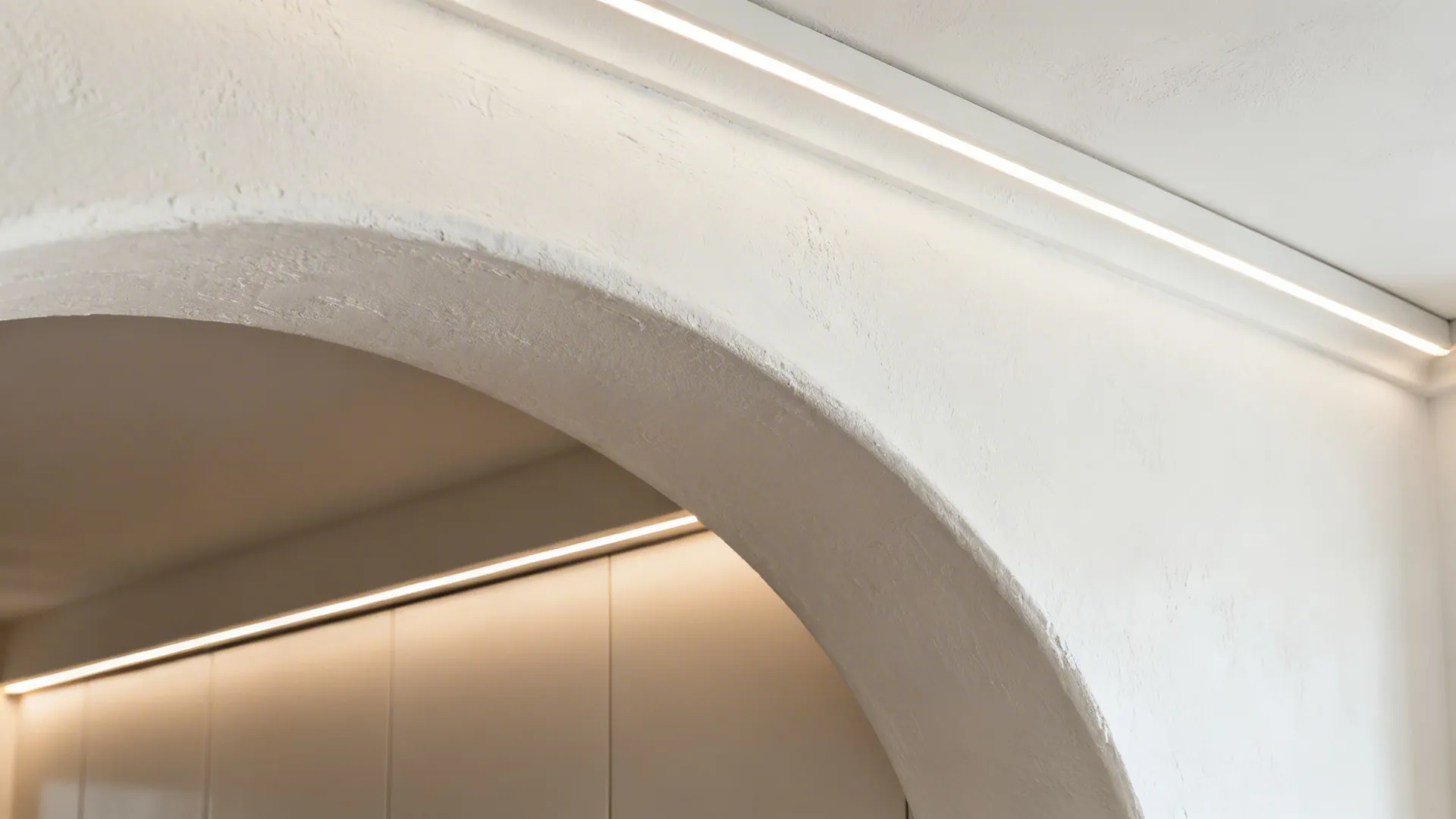 Macro view of a smooth plaster arch soffit with integrated LED cove lighting.