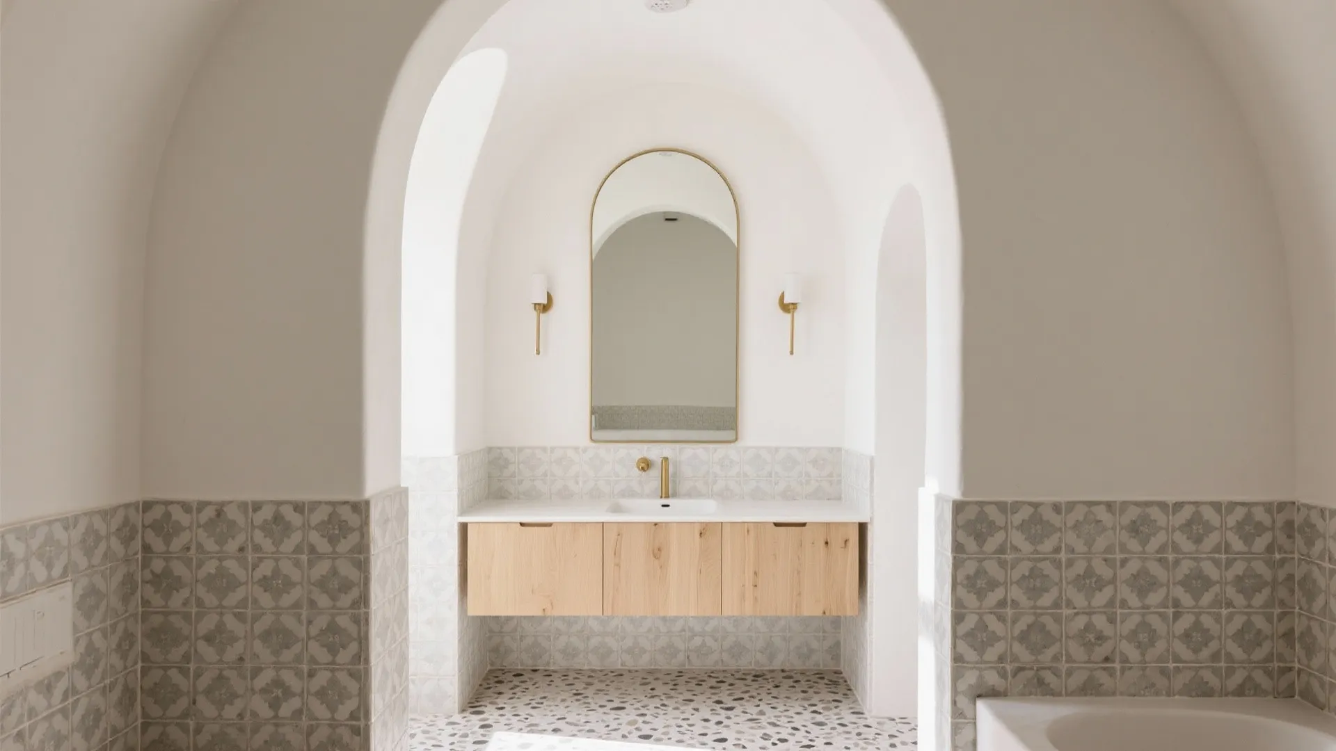 White bathroom design featuring arched doorway wooden cabinet gold wall light arched mirror and tiles