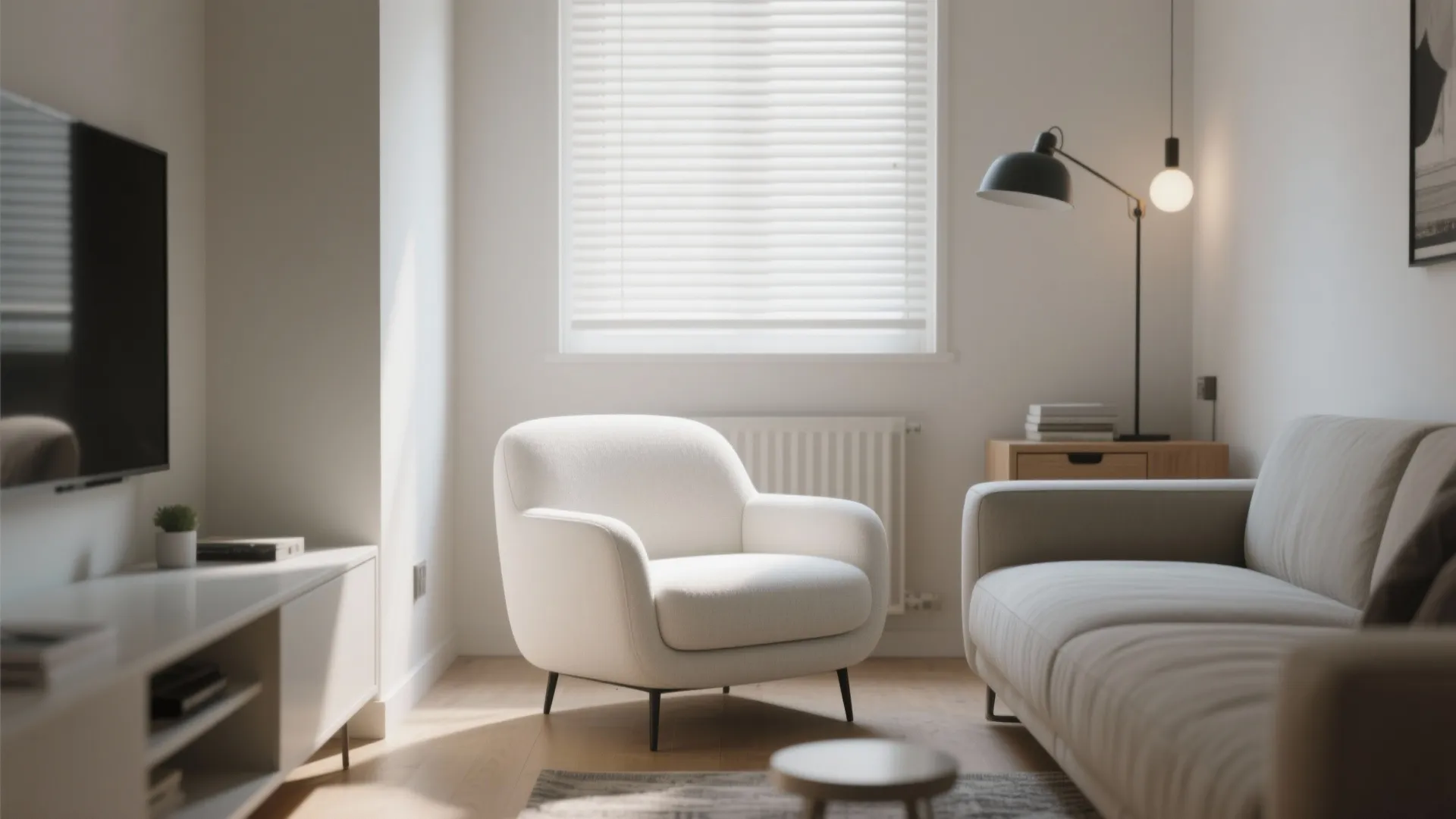 Compact armless white club chair tucked beside a sofa in a studio living room.