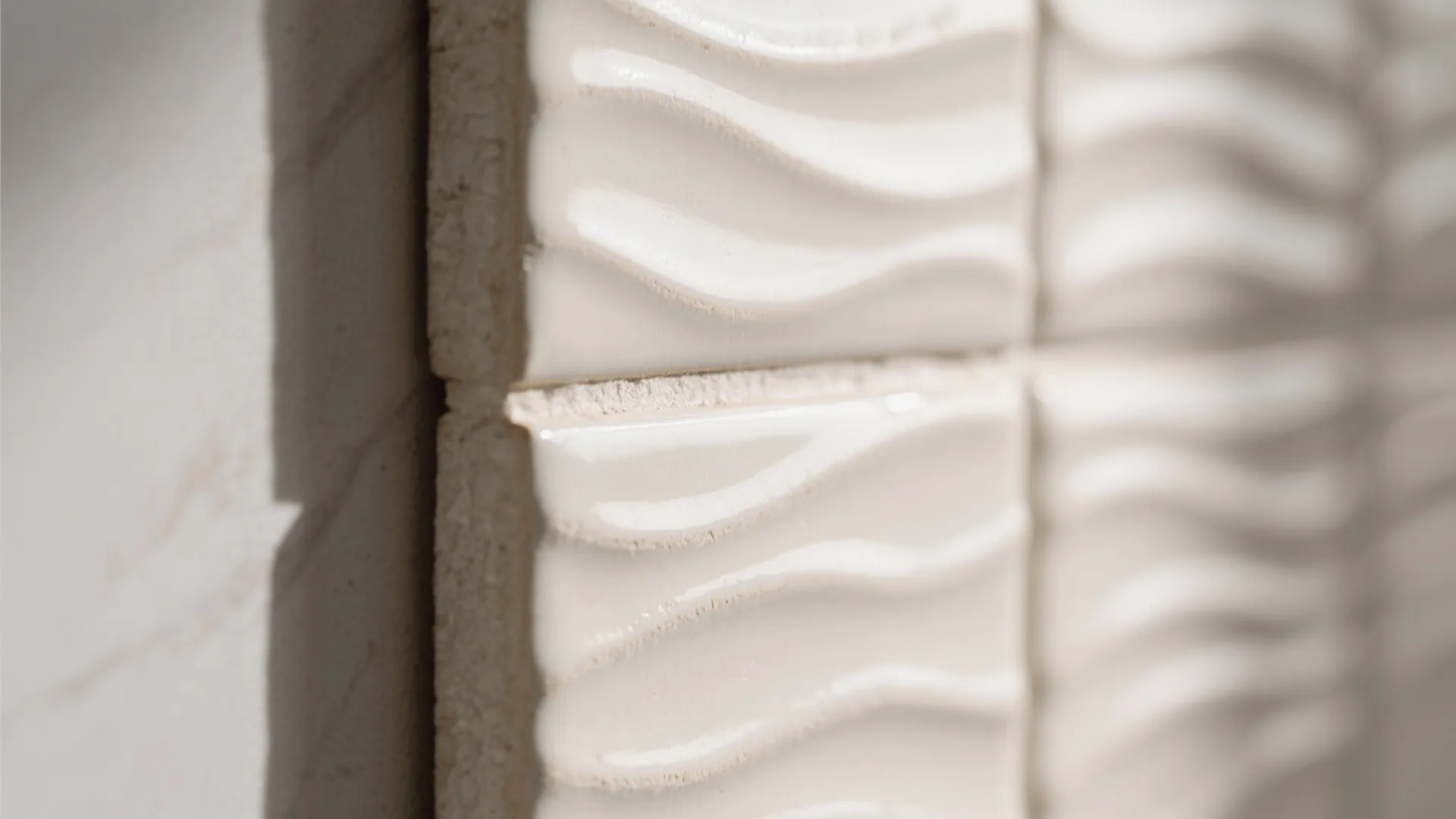 Close up view of white wall tiles with wavy pattern and glossy finish in modern room