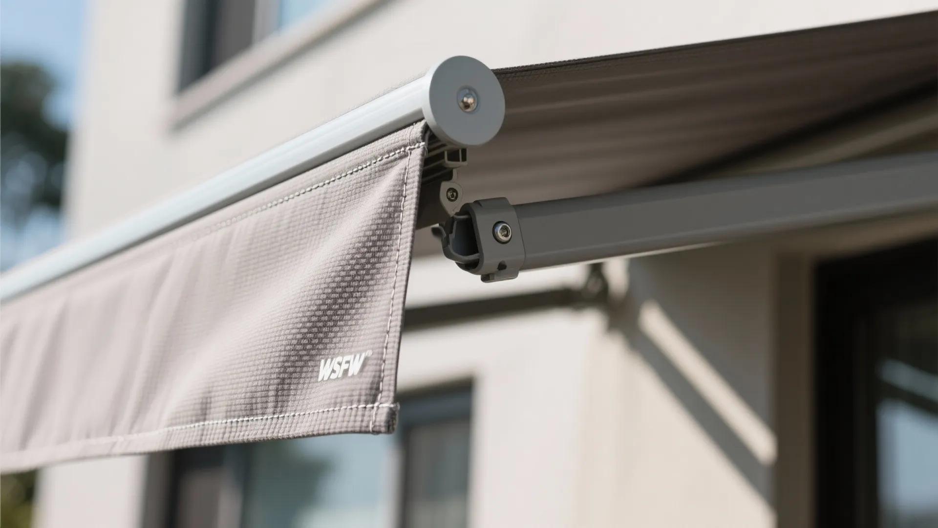 Macro view of awning fabric weave and powder-coated bracket with clean stitching.