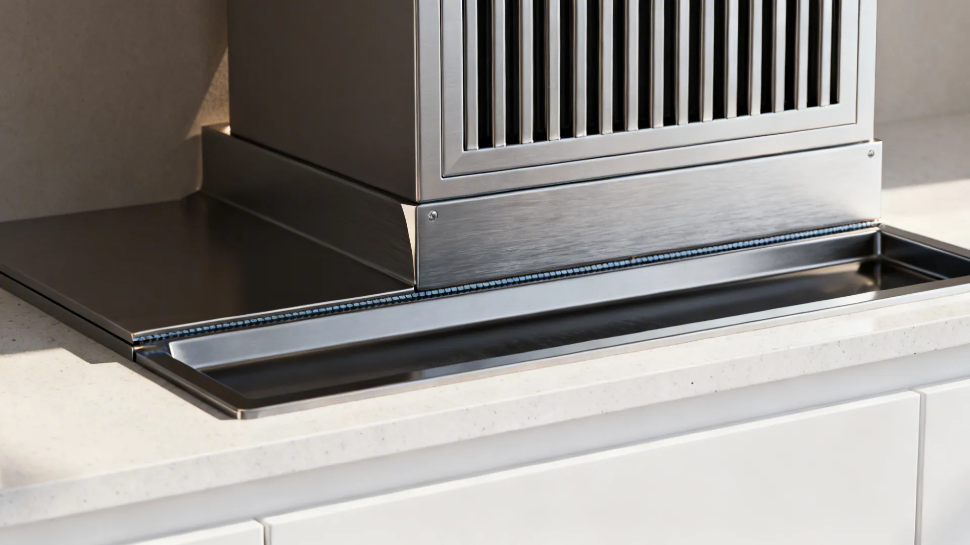 Macro of chimney baffle filter and brushed steel fascia with oil collector seam.