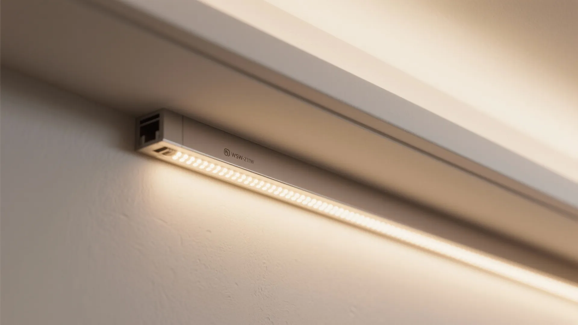 Close up view of warm white led strip light fixture installed under a wall ledge