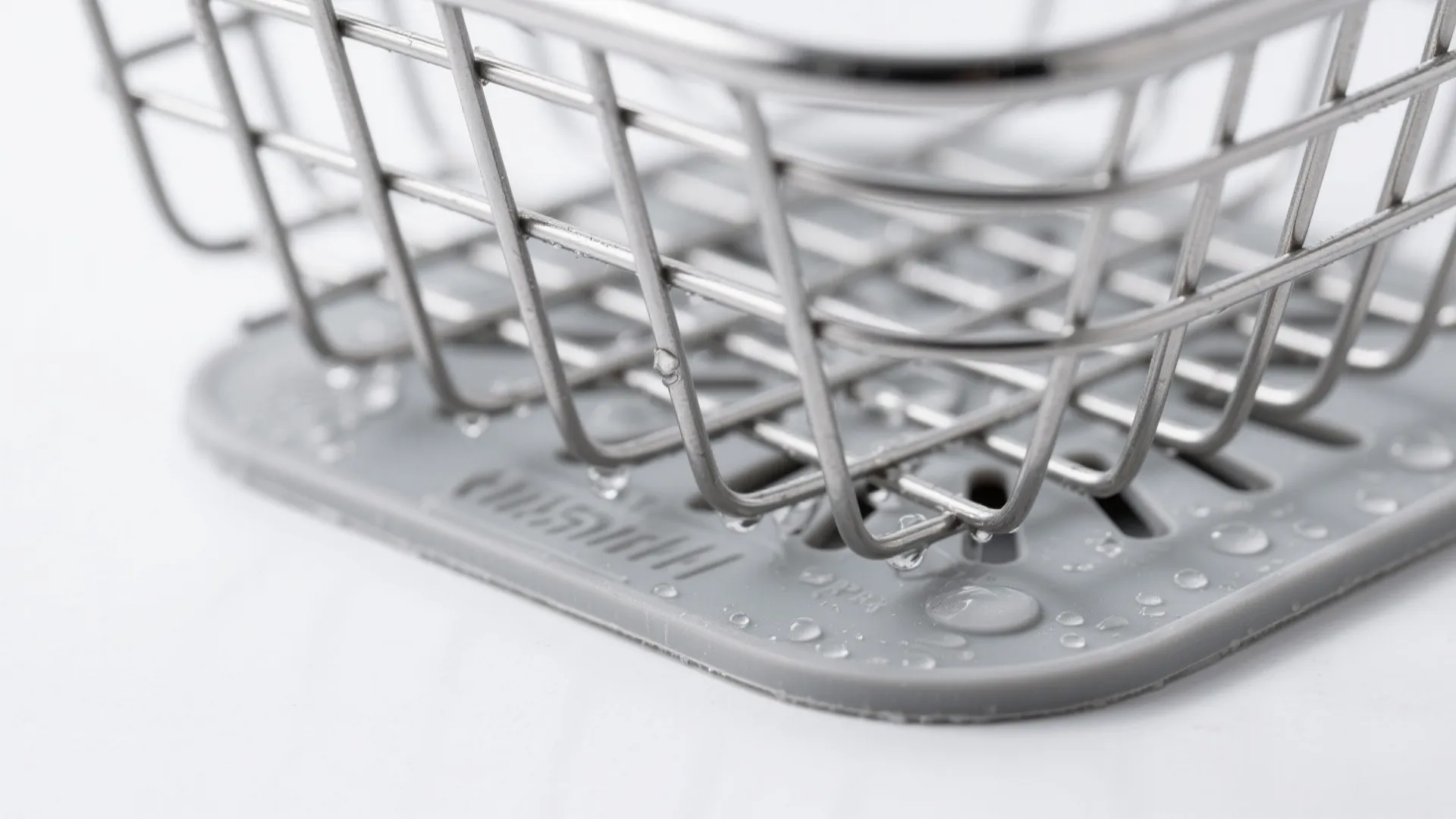 Macro of stainless wire basket drain base with silicone pad and airflow gaps.