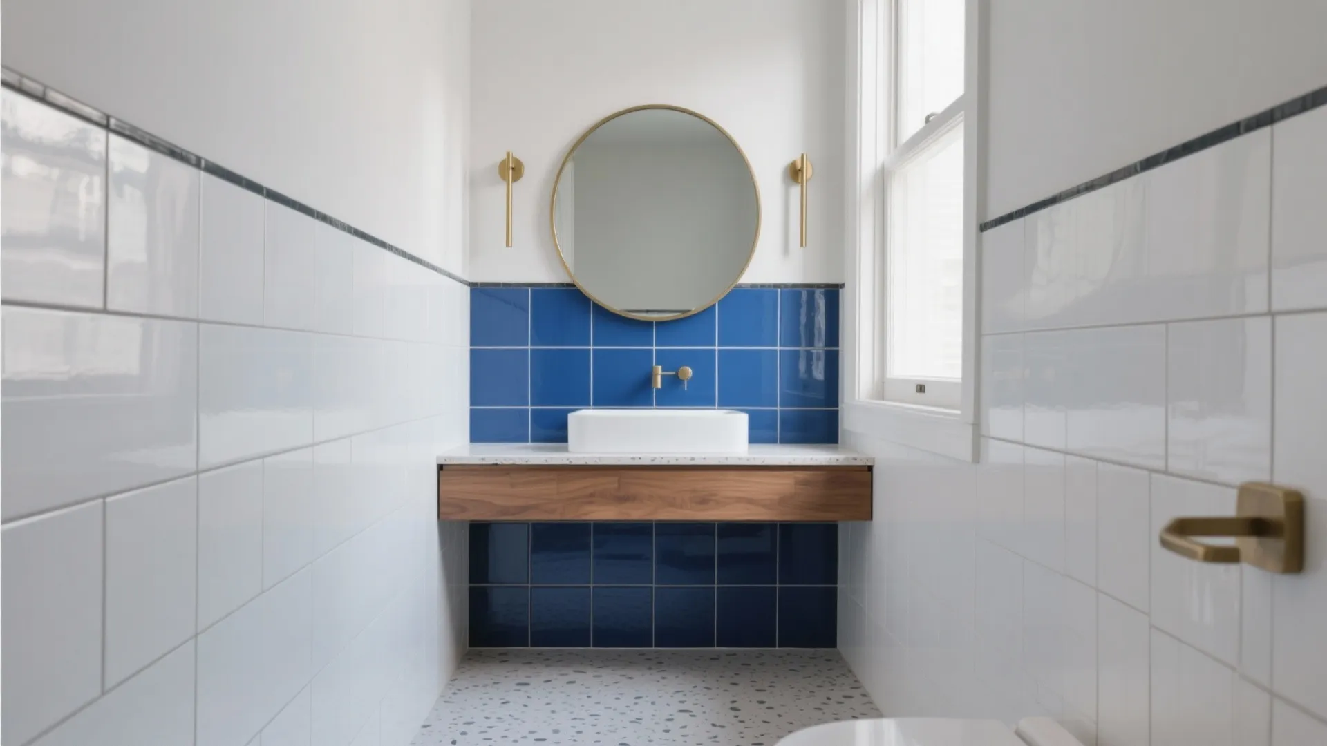 Modern bathroom with blue wall tiles round mirror white sink wooden cabinet and terrazzo floor