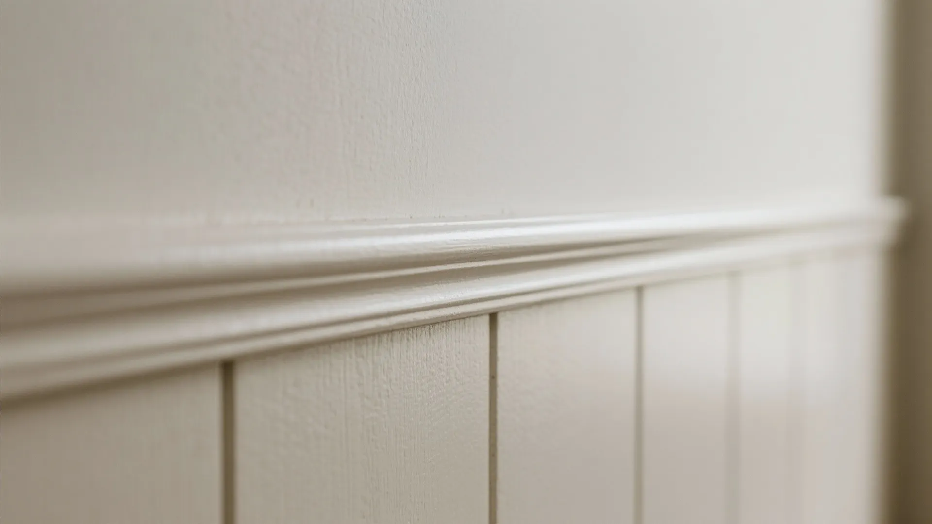 Close up of white wall panel details with vertical lines and horizontal trim in bright light