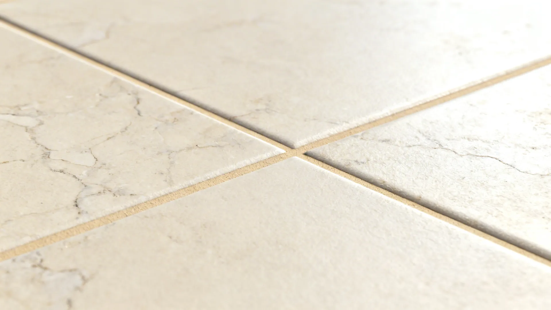 Macro of matte cream porcelain tile veining with matching beige grout under soft raking light.