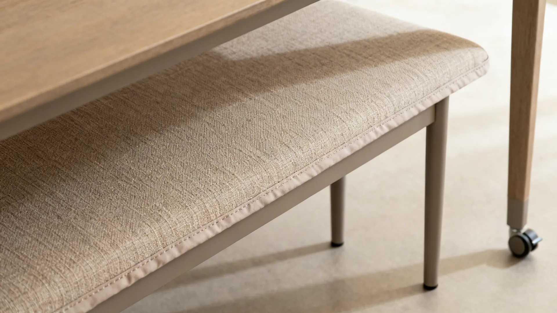 Close-up of bench upholstery and table apron clearance with powder-coated leg detail.