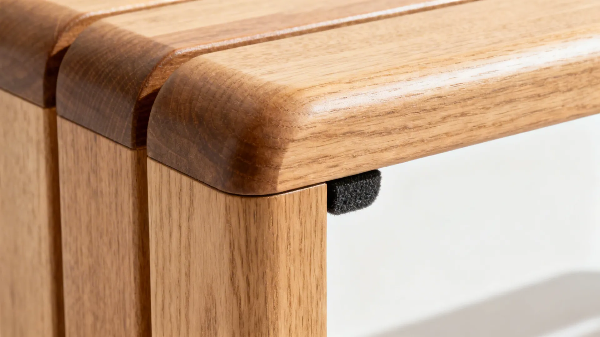 Macro of backless bench corner with rounded edge and felt glides.