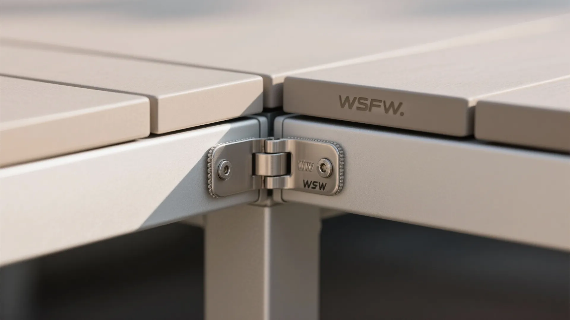 Close up detail of a metal hinge connecting two light grey outdoor furniture panels with screws