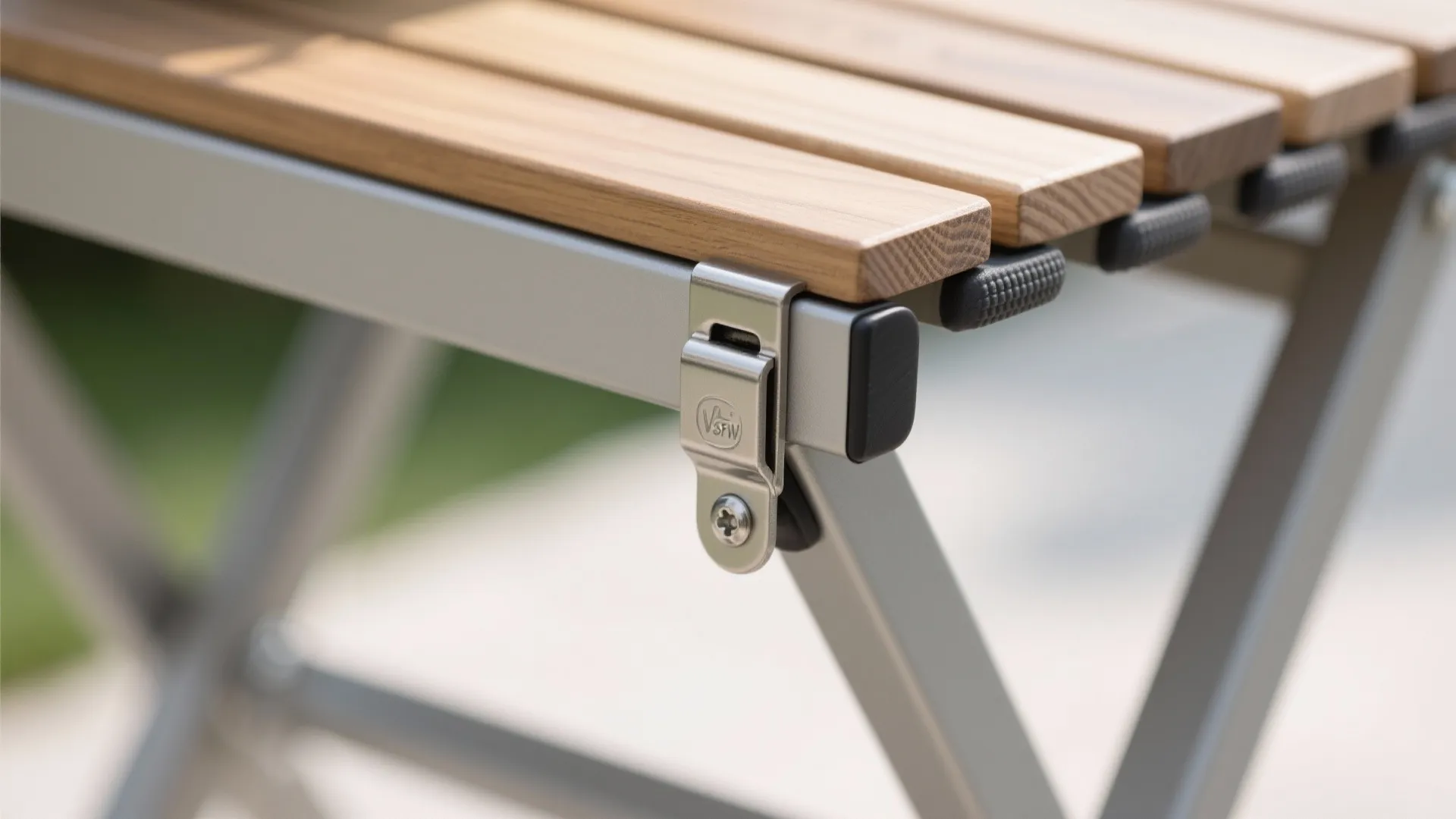 Close-up of stainless hinge and wood grain on a foldable bench.