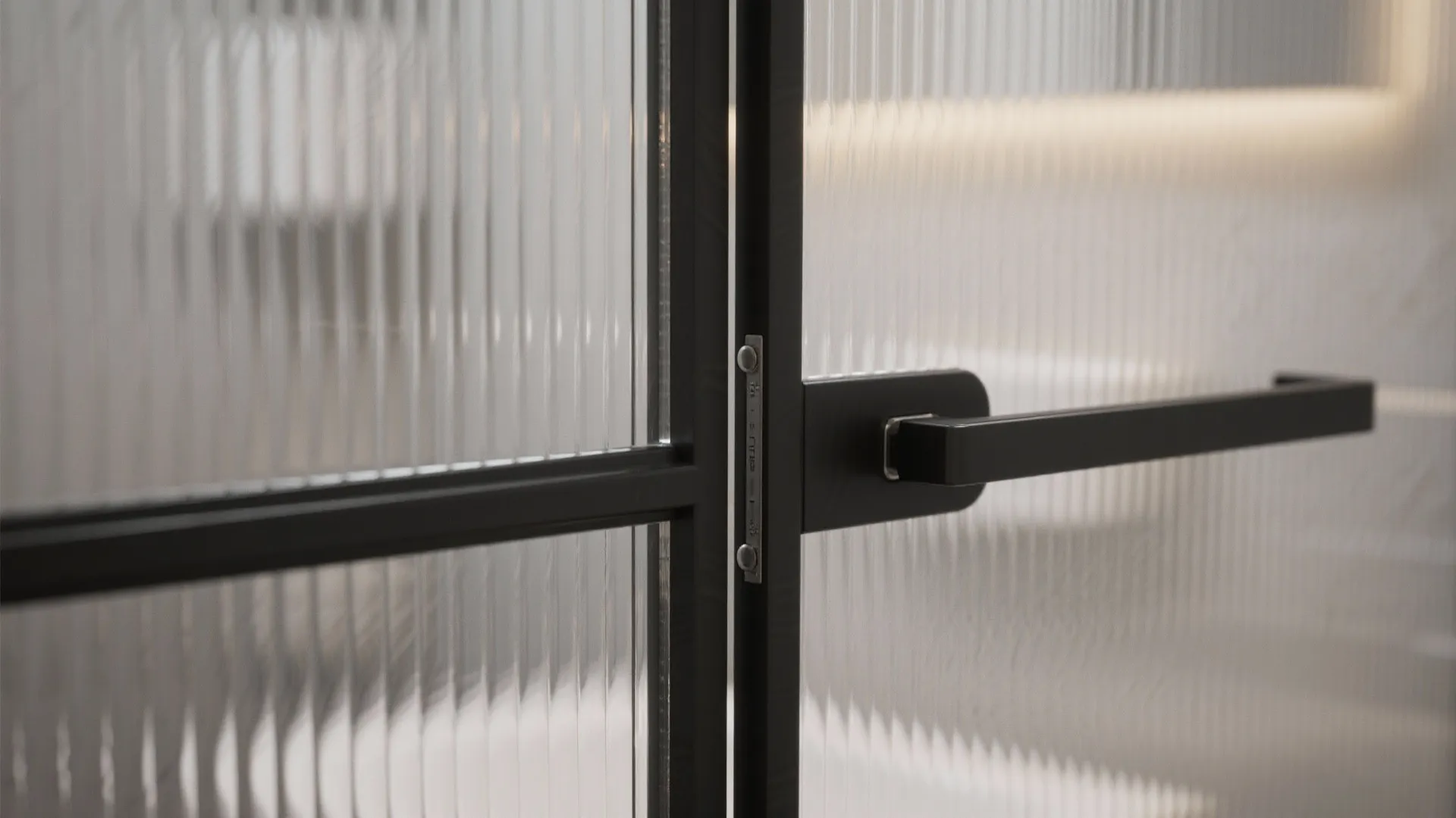 Modern black metal frame door with ribbed glass panels and a sleek black handle in detail