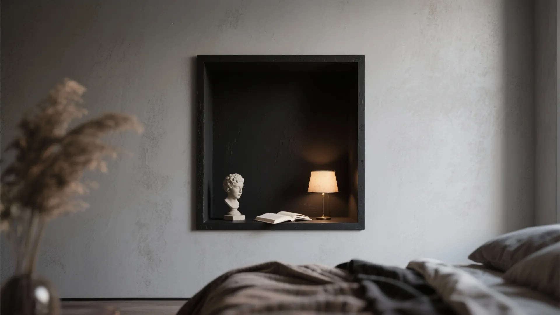 Small black-painted niche framed within a light wall featuring a lamp and sculpture