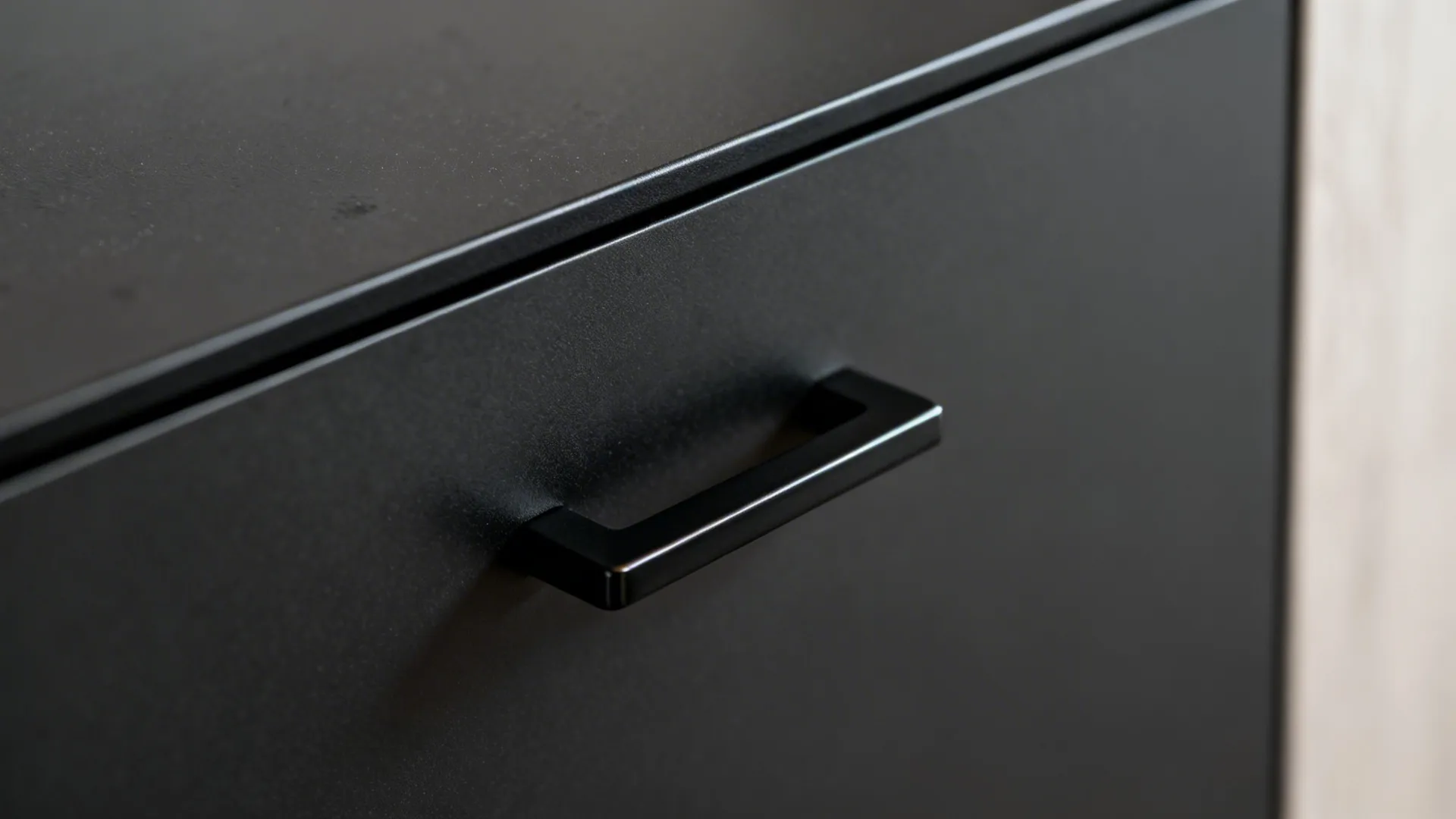 Macro of matte black cabinet with 2 mm black ABS edge band and black pull.