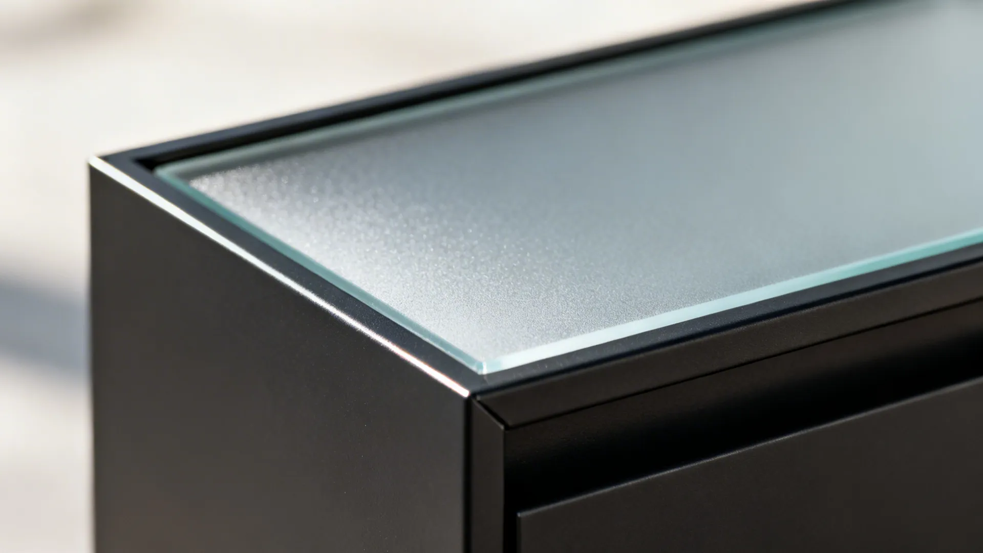 Close-up of frosted glass set in a slim black aluminum cabinet frame.