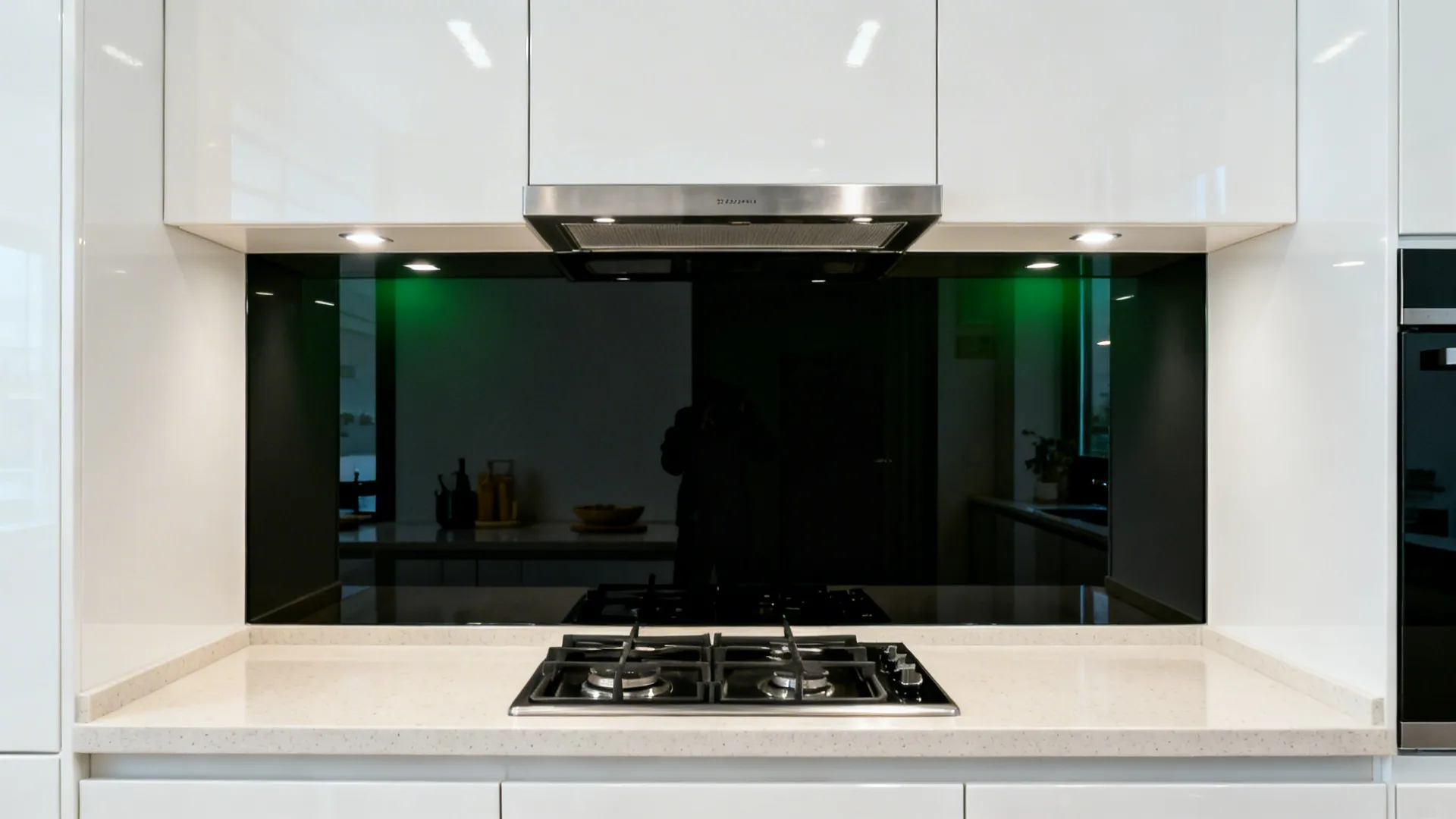 Gloss white uppers above a seamless black tempered-glass backsplash reflecting light.