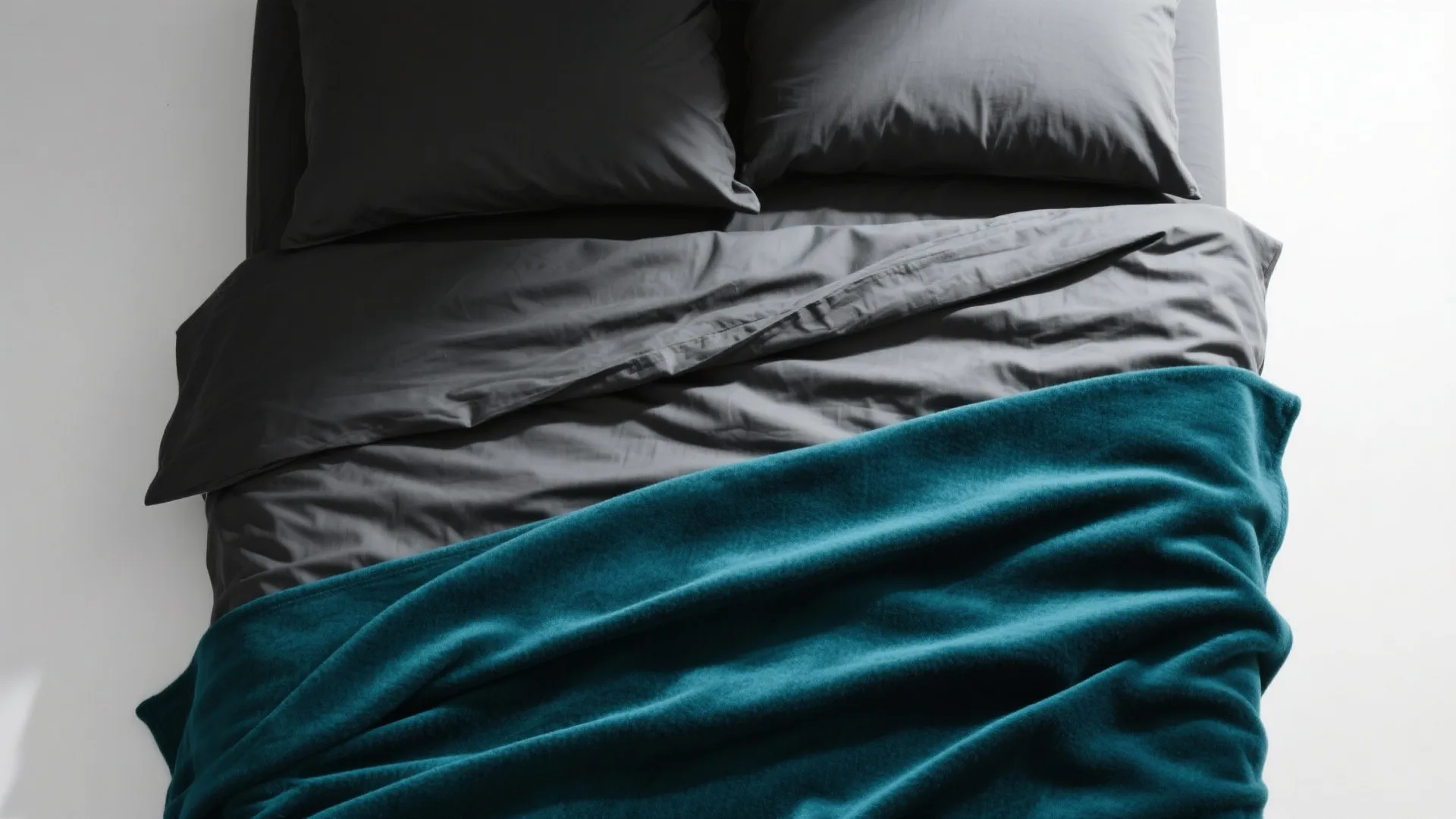 Layered bedding in black, grey, and teal colors