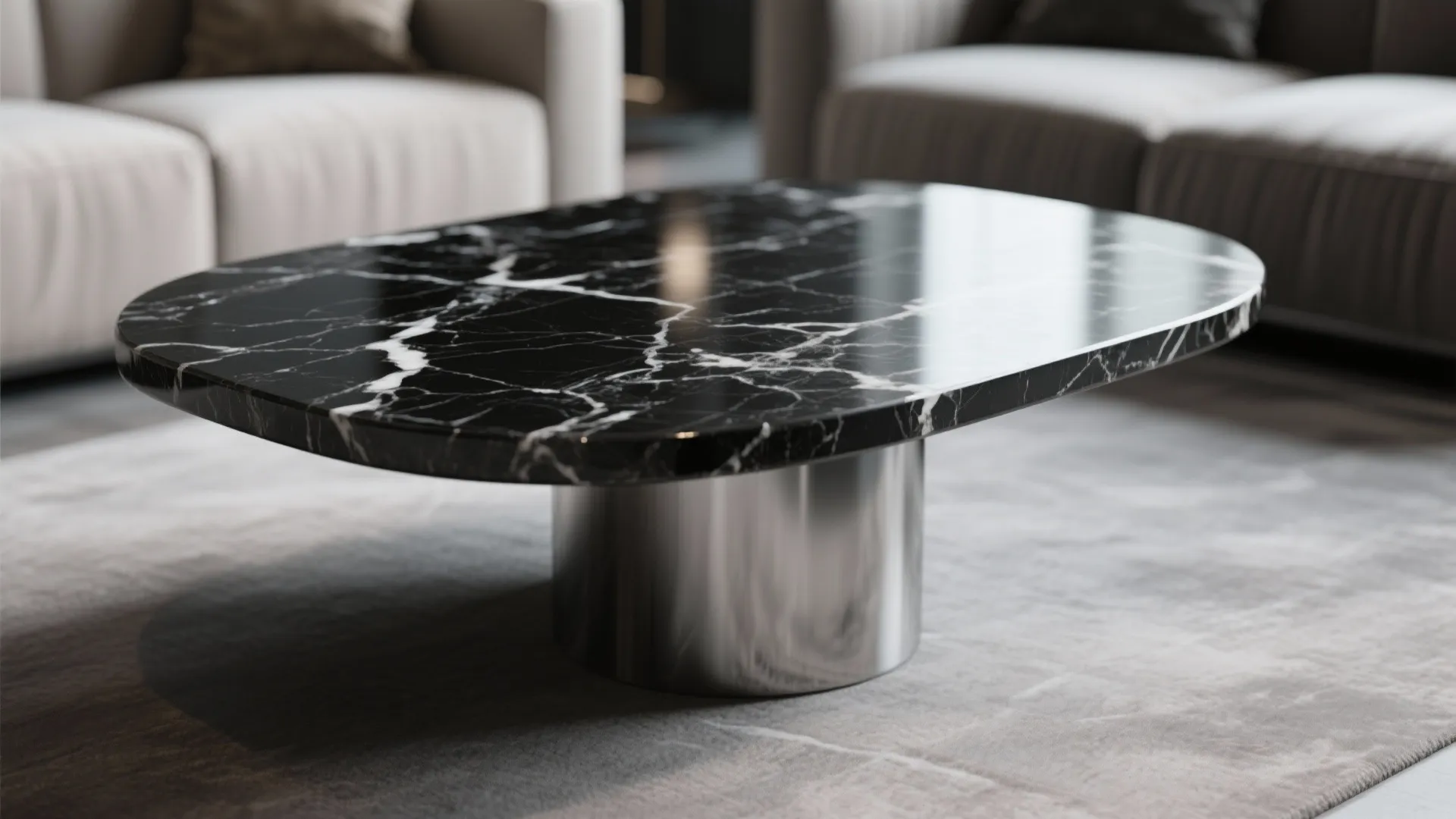 Oval black marble coffee table with silver metal base placed on grey rug in room