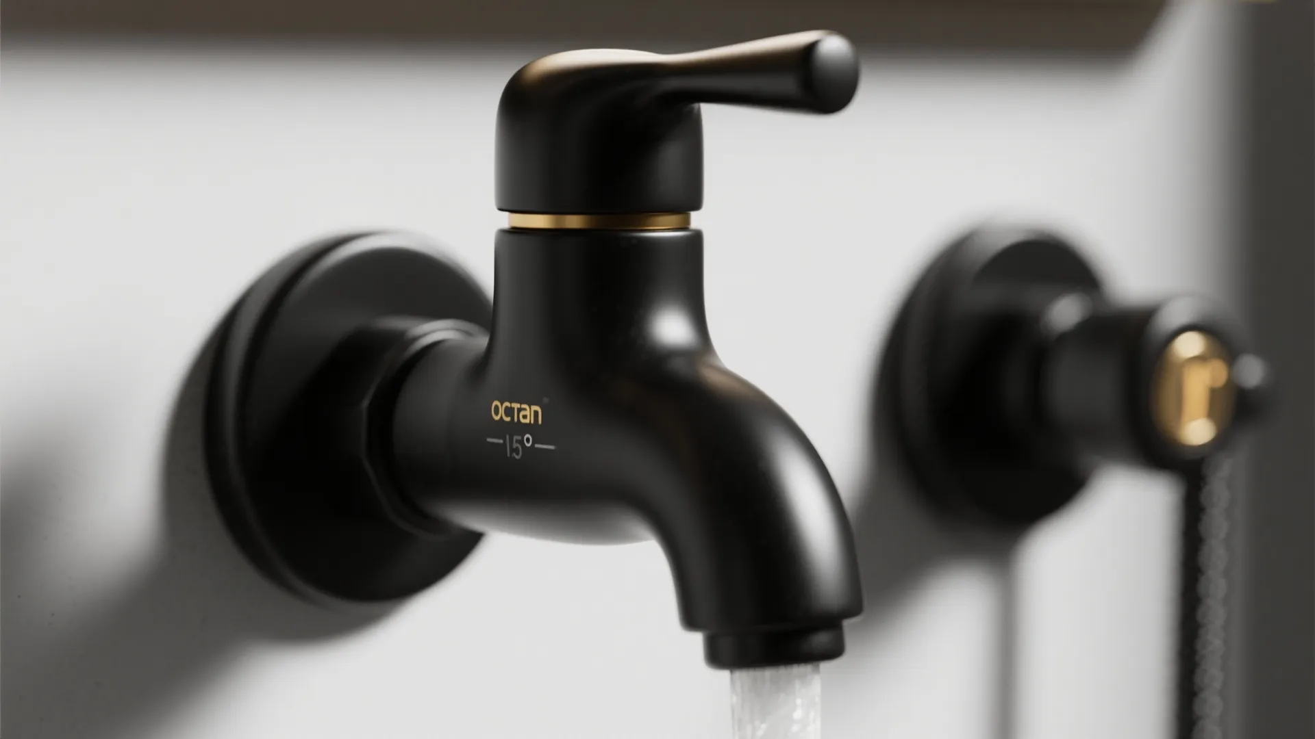 Close up of a wall mounted black water tap with small gold details and running water