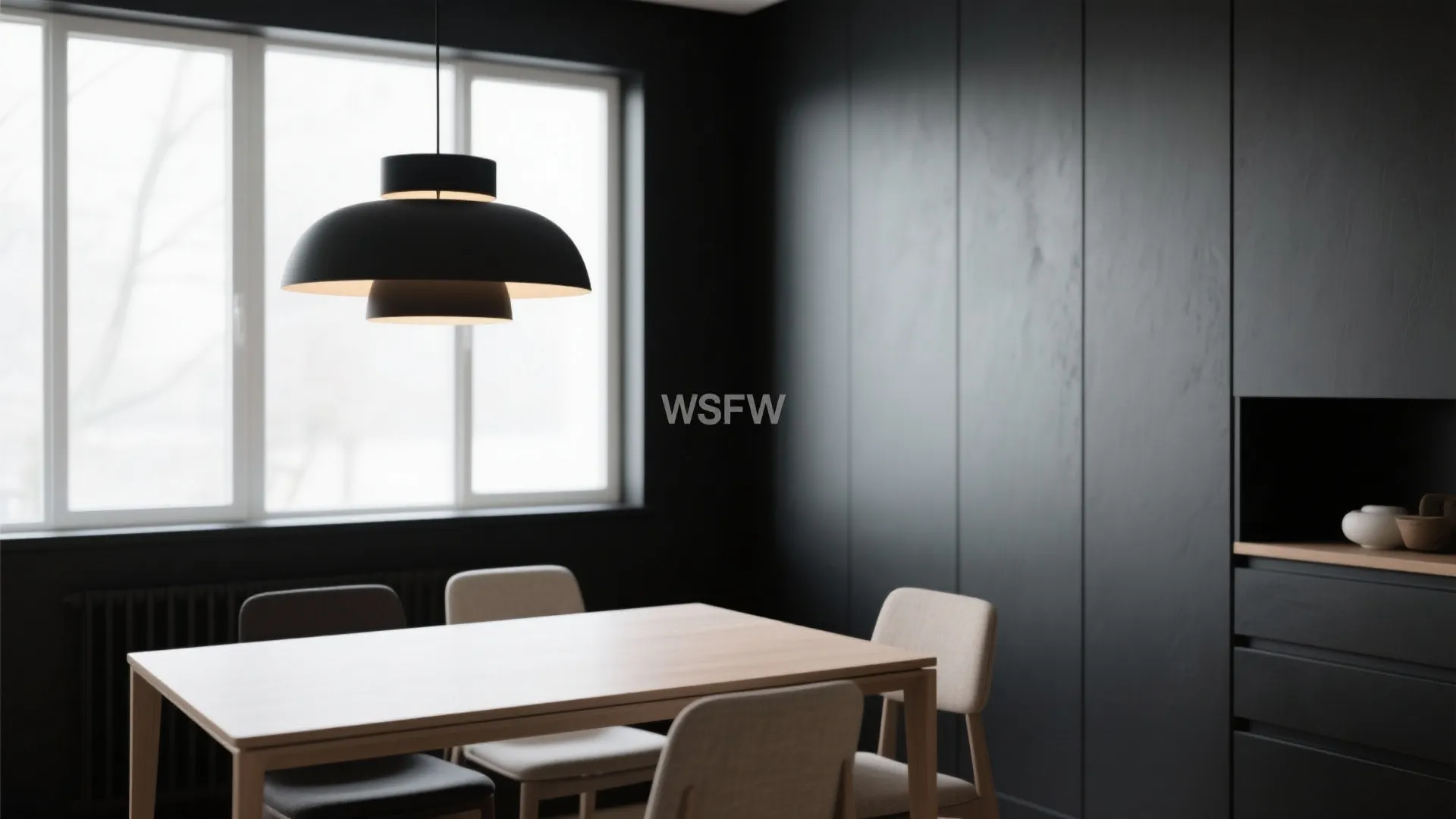 Minimalist dining room with black walls and statement lighting