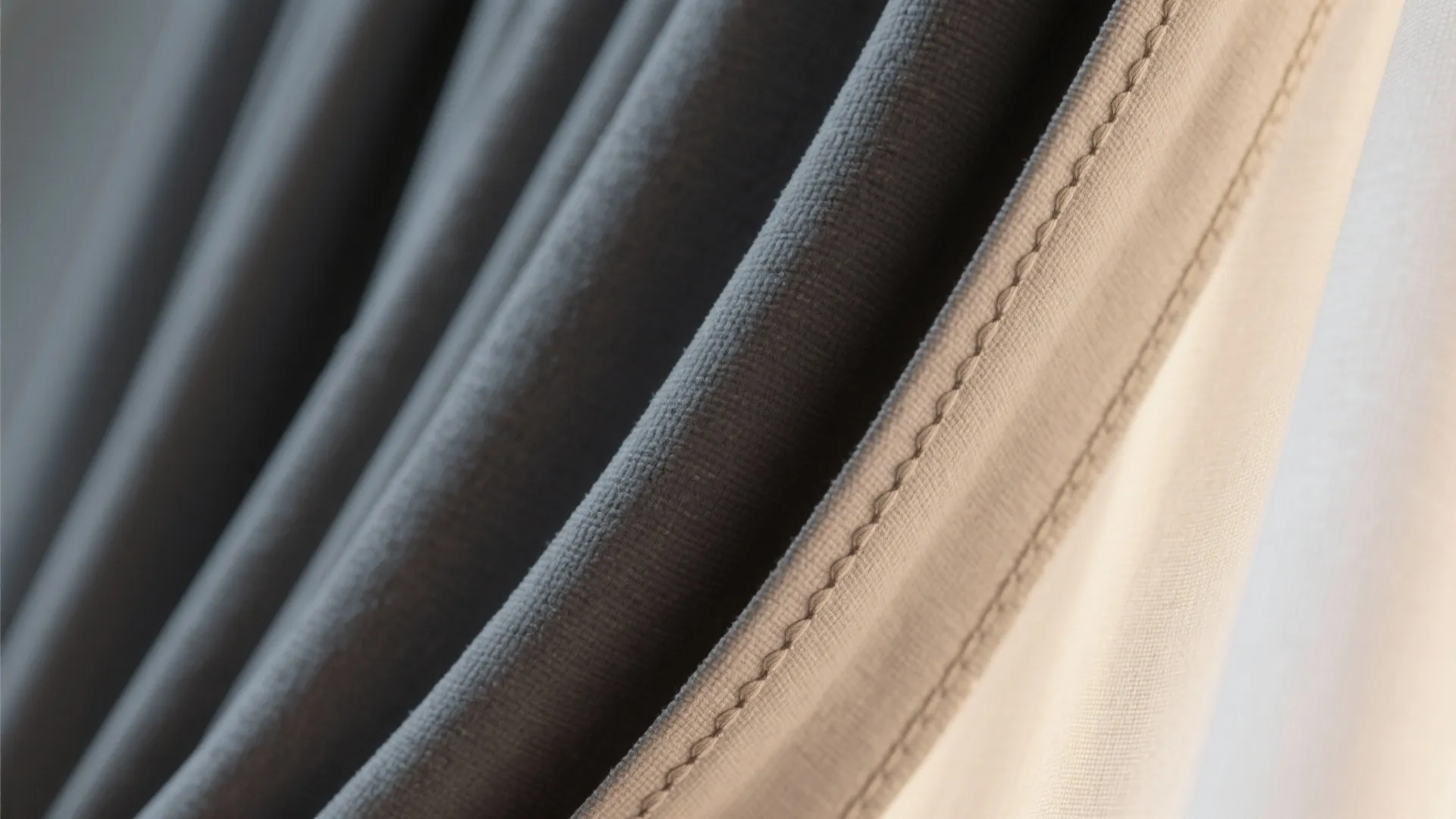 Close-up of soft blackout fabric with cotton lining and neat stitching, showing layered construction.