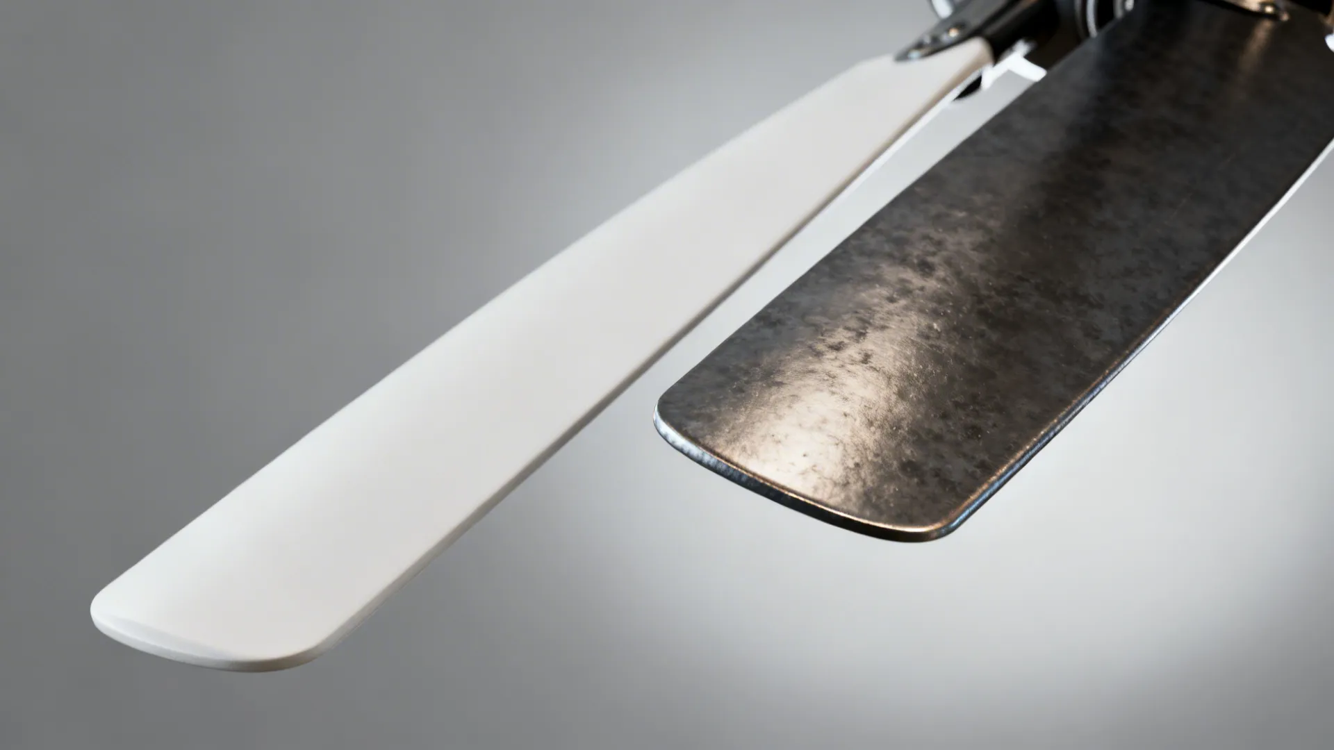 Close-up comparison of slim white tapered fan blade beside a dark chunky blade showing perceived size differences.