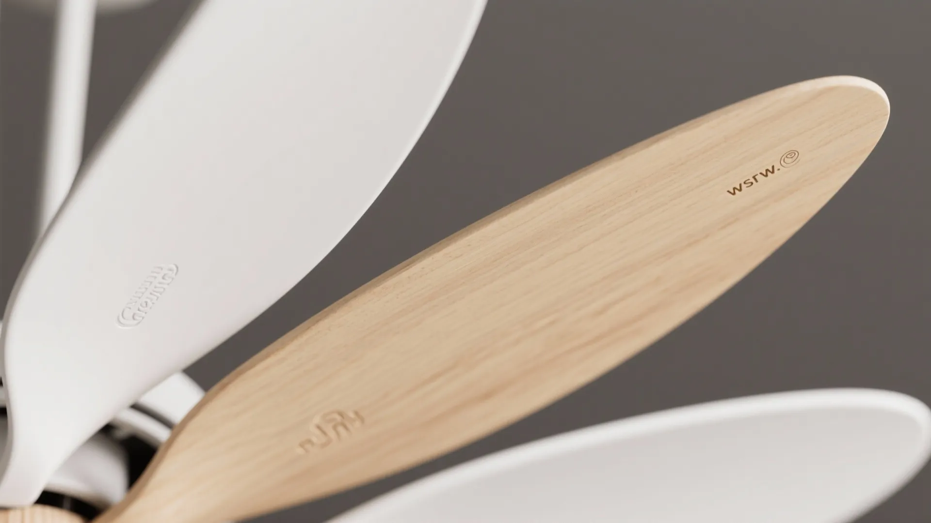 Close up of white and wood grain ceiling fan blades showing smooth texture and small logo