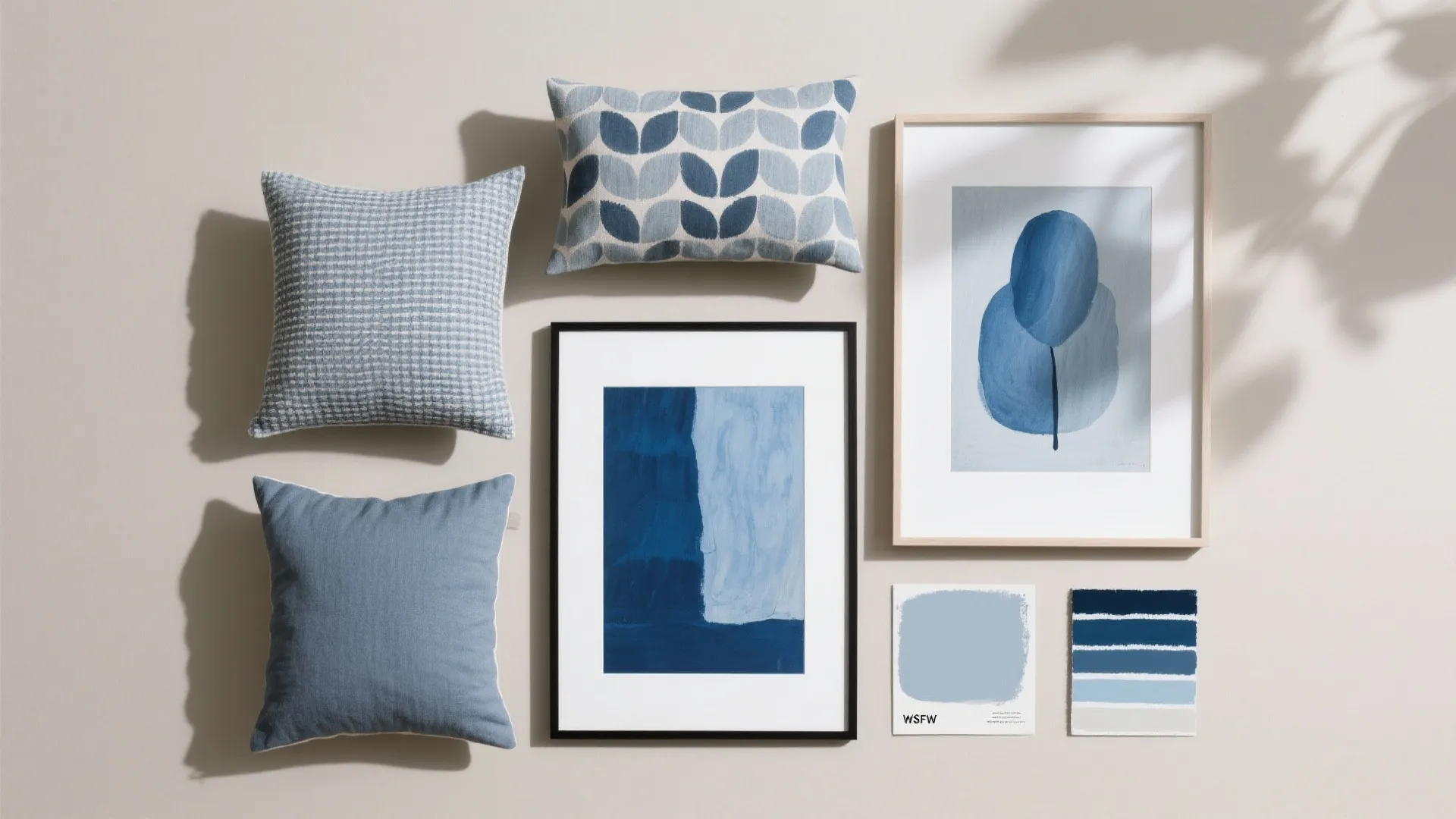 Interior design mood board with blue patterned pillows framed wall art and blue color paint swatches